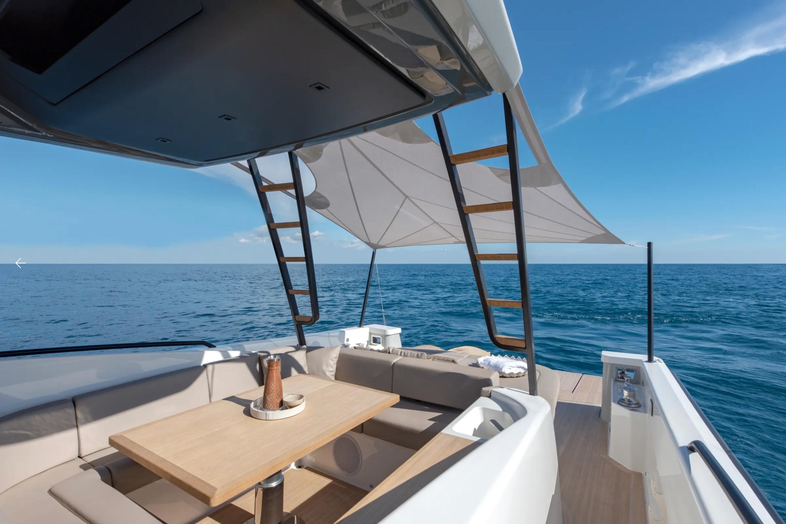 A modern boat with a shaded seating area on calm water.