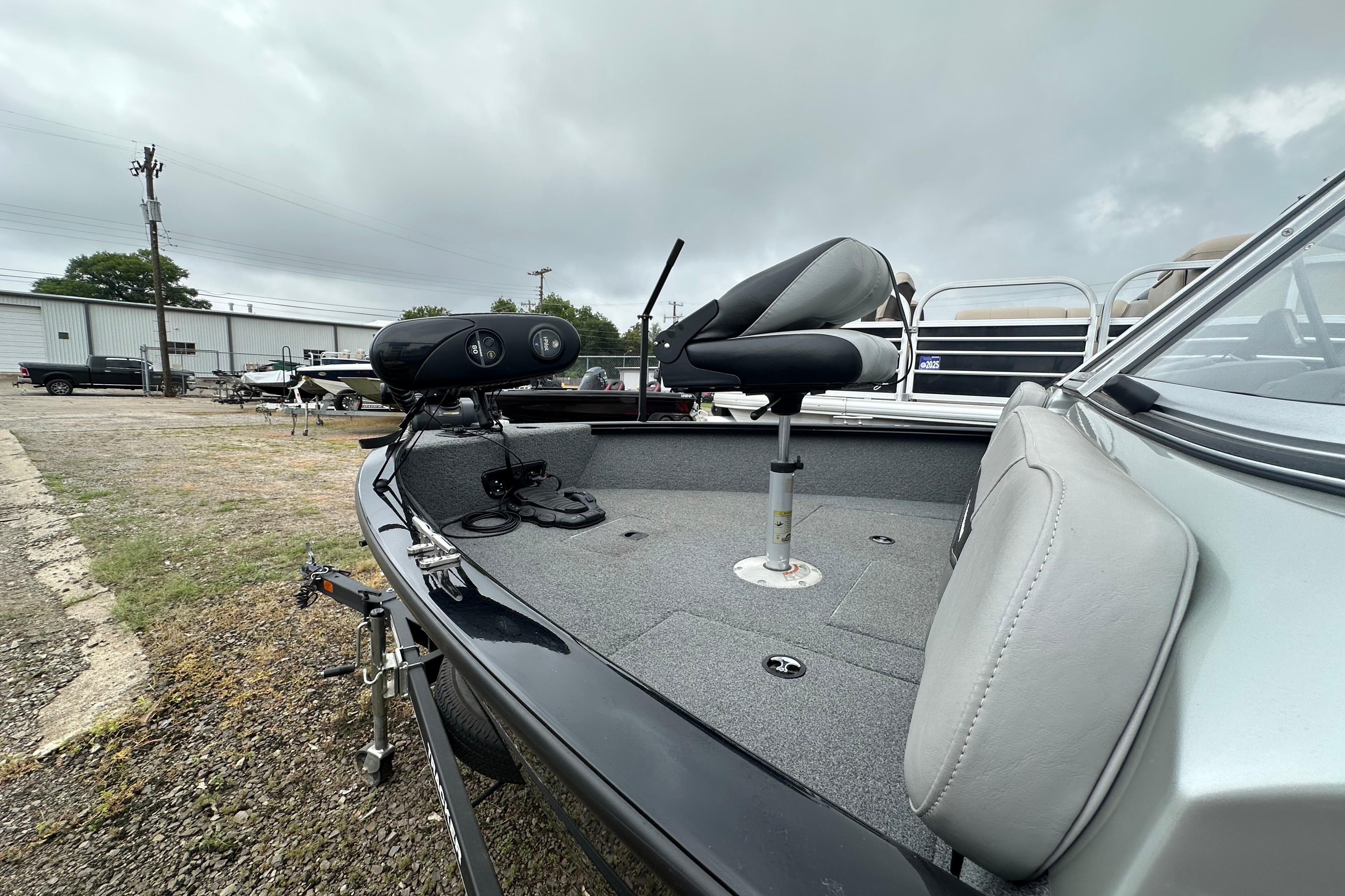 2018 Tracker Pro Guide V-175 Combo boat with seating and equipment on a cloudy day.