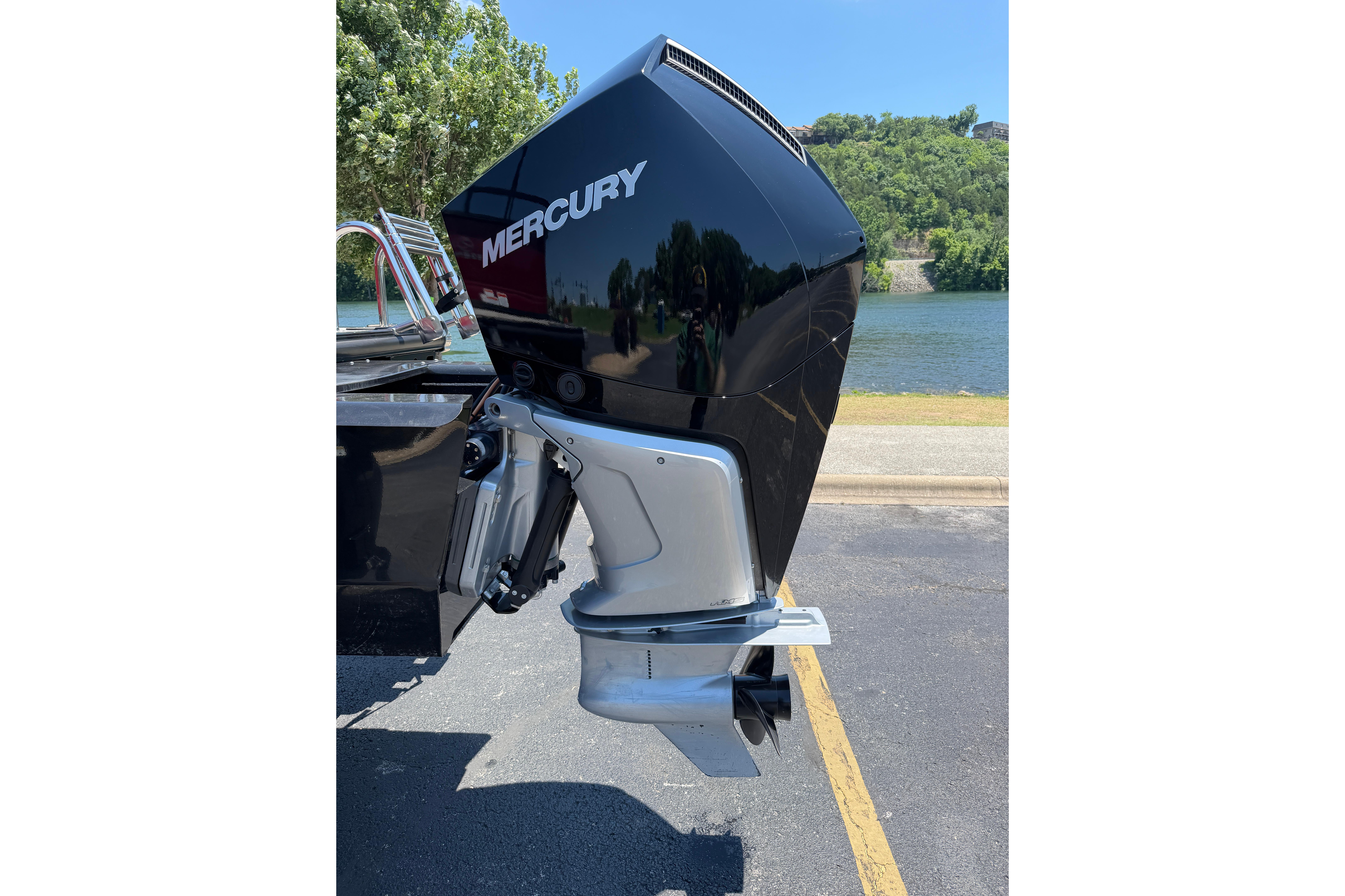 2024 Regency R250DL3 boat with Mercury outboard motor by a scenic lake.