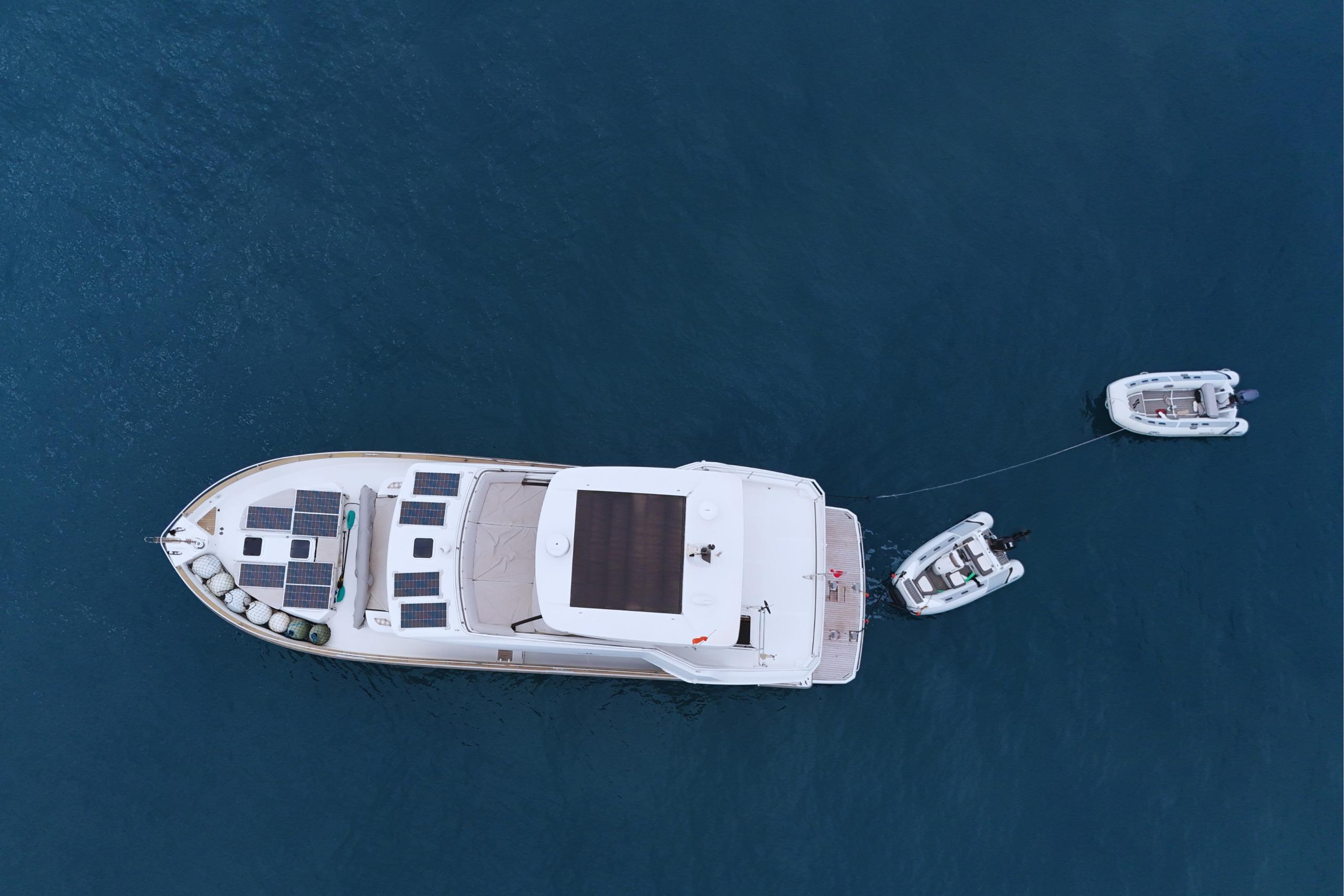 Overhead view of 2020 Cranchi T55 Trawler with two small boats in blue water.