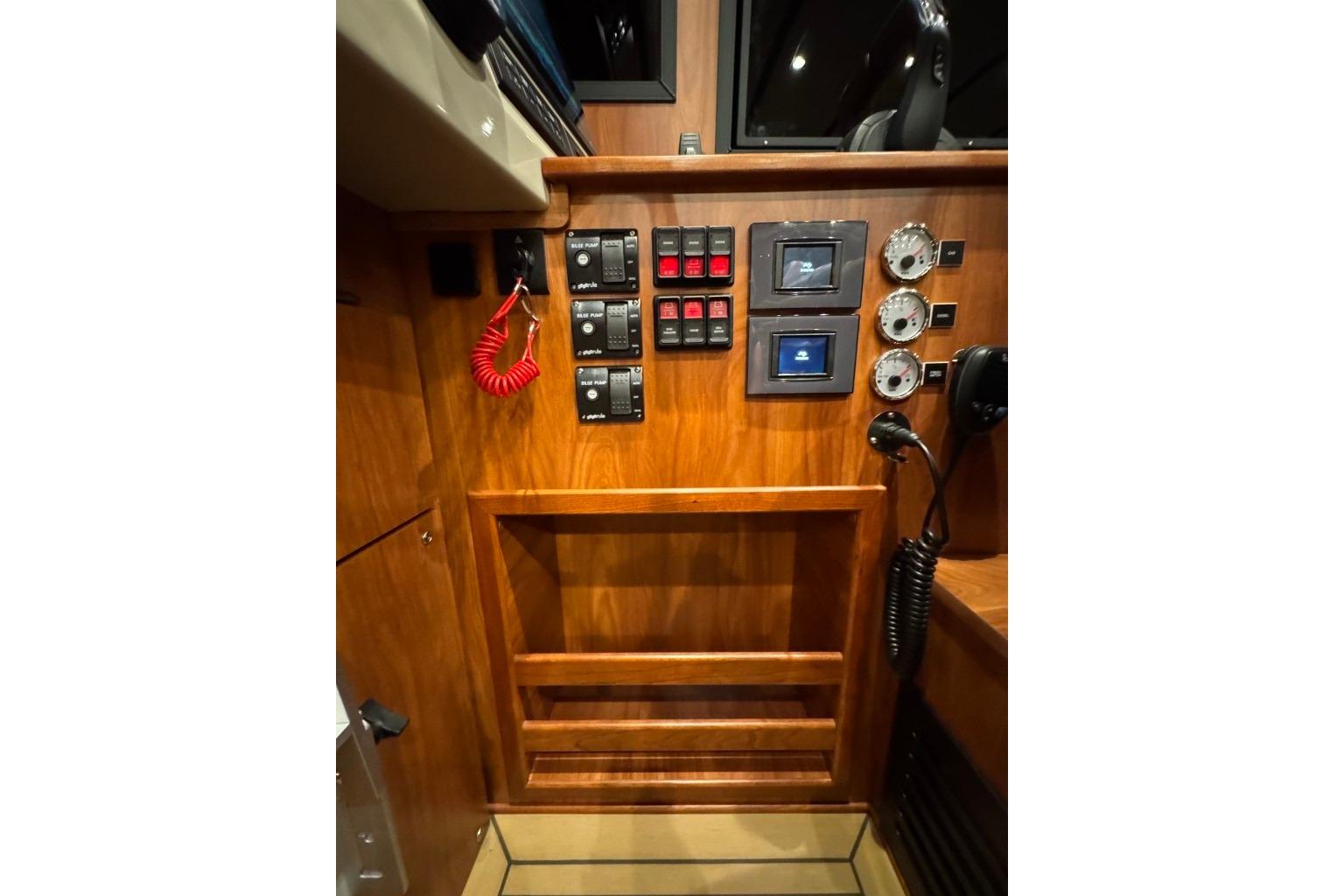 Control panel of 2026 EagleCraft 42' Cruiser with switches, gauges, and communication equipment.