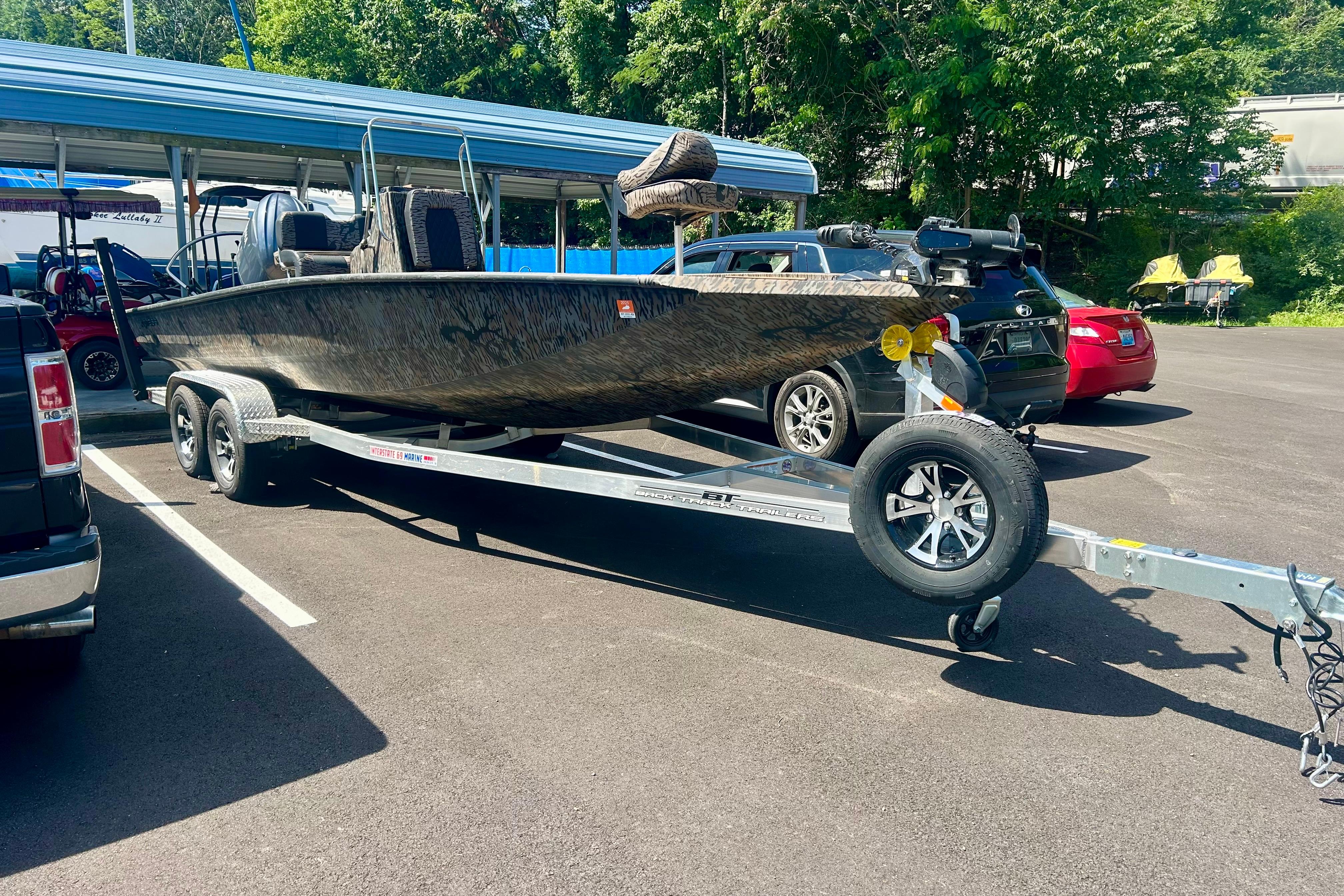 2025 Xpress H22B Bay boat on trailer in parking lot, surrounded by cars.