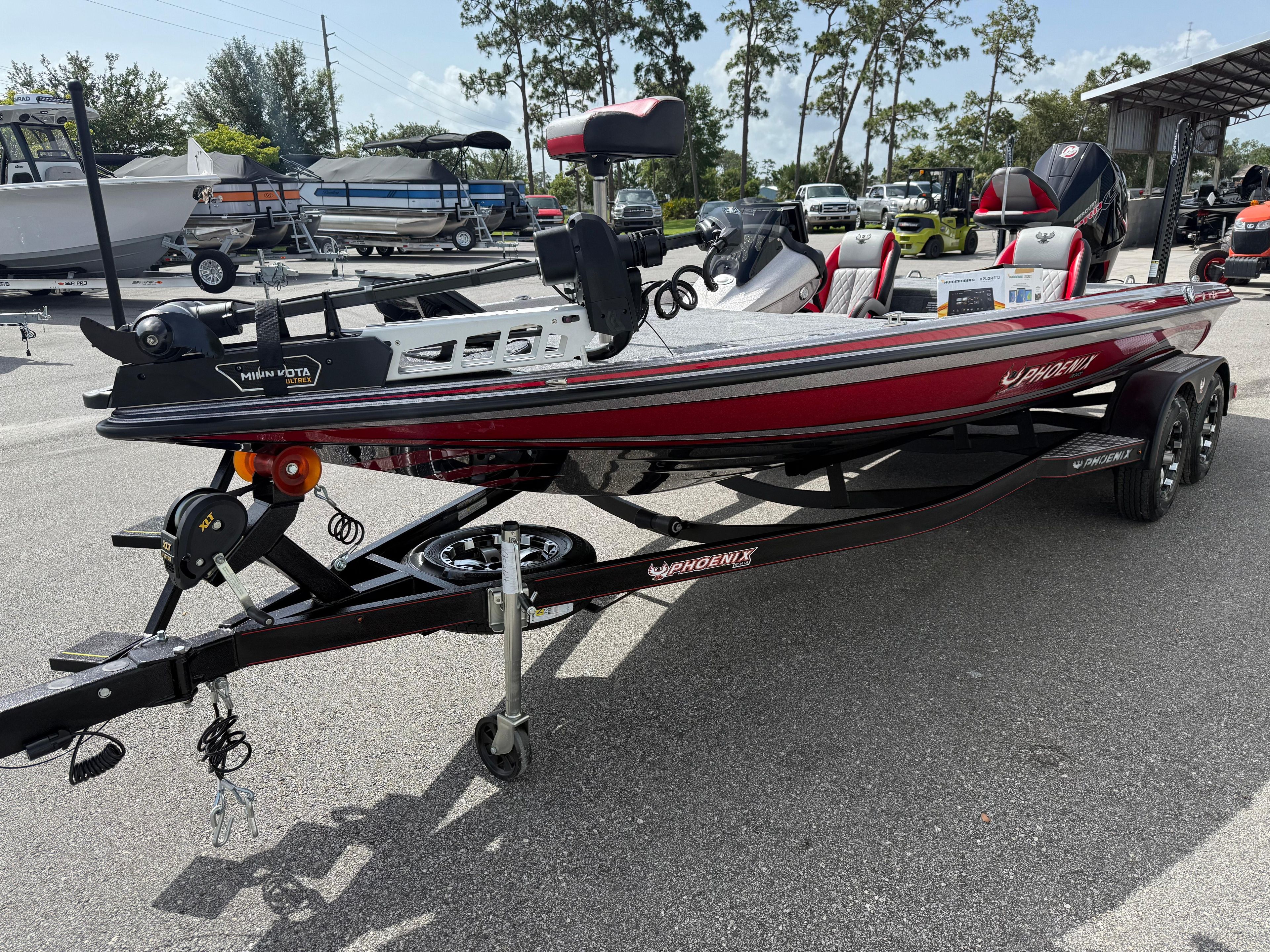 2026 Phoenix 721 ZXL boat on trailer, red and black design, parked outdoors.