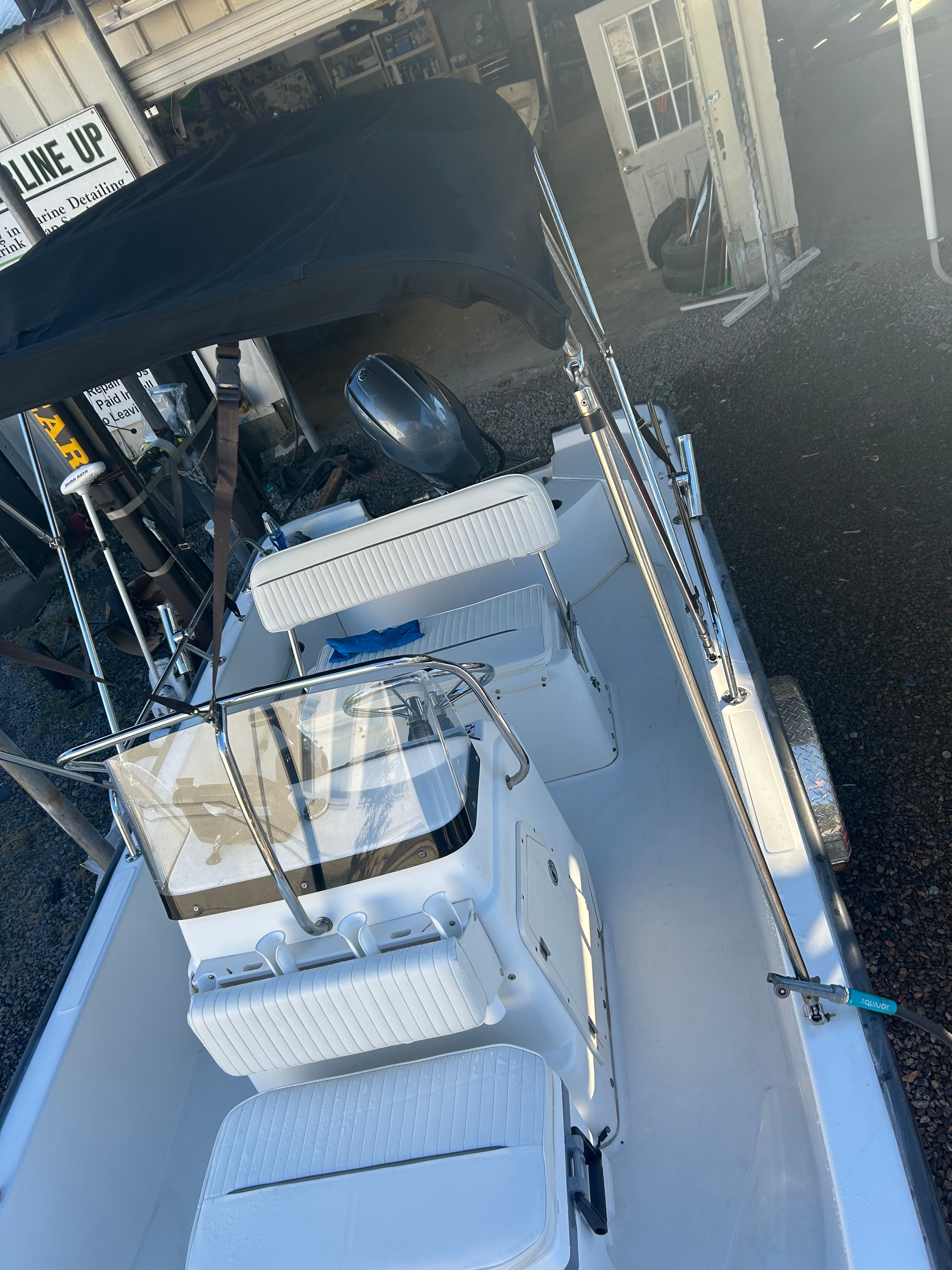2006 Boston Whaler 150 Montauk boat with black canopy.