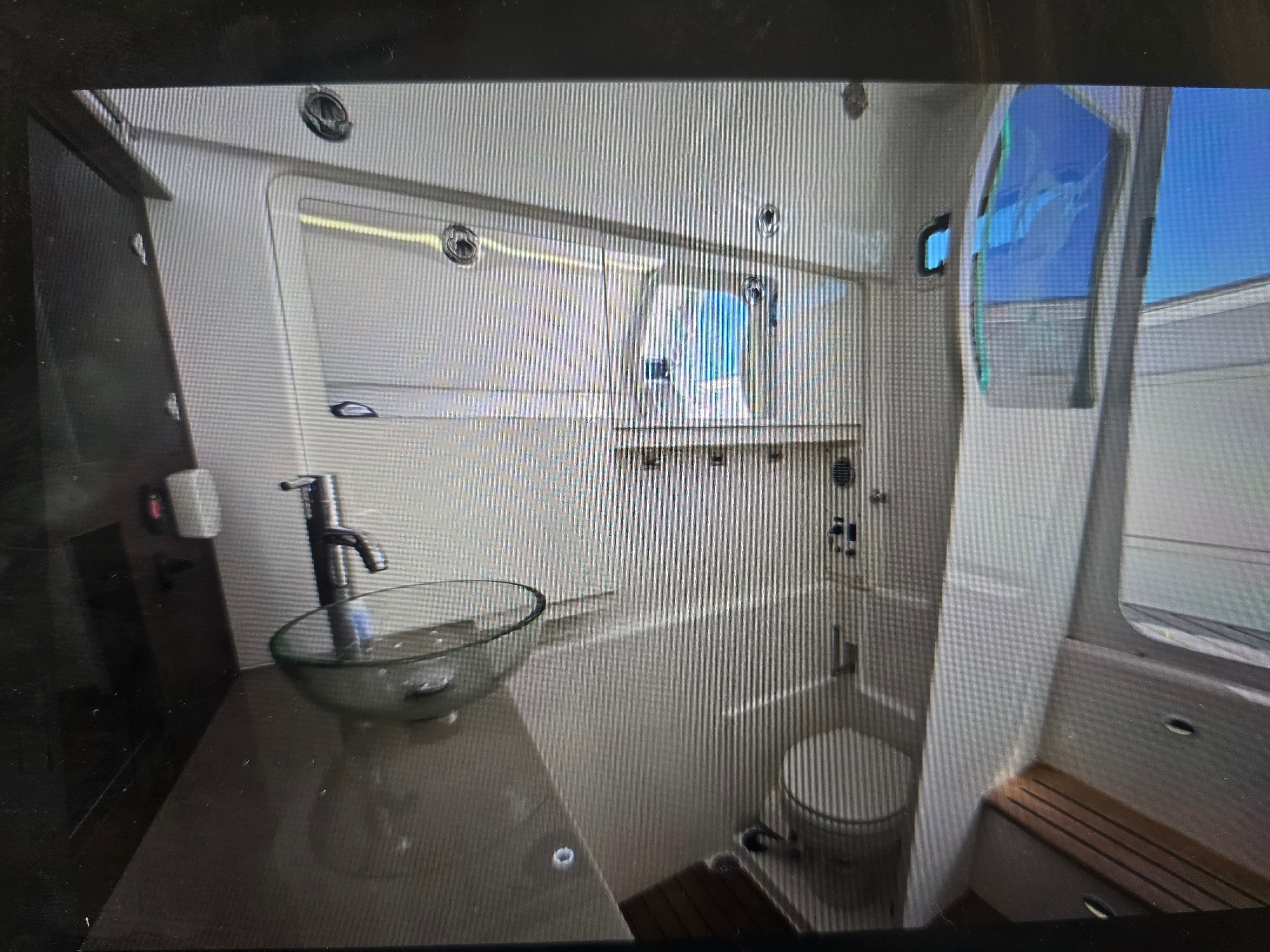 Interior of 2019 Everglades 435 Center Console with bathroom and sink.