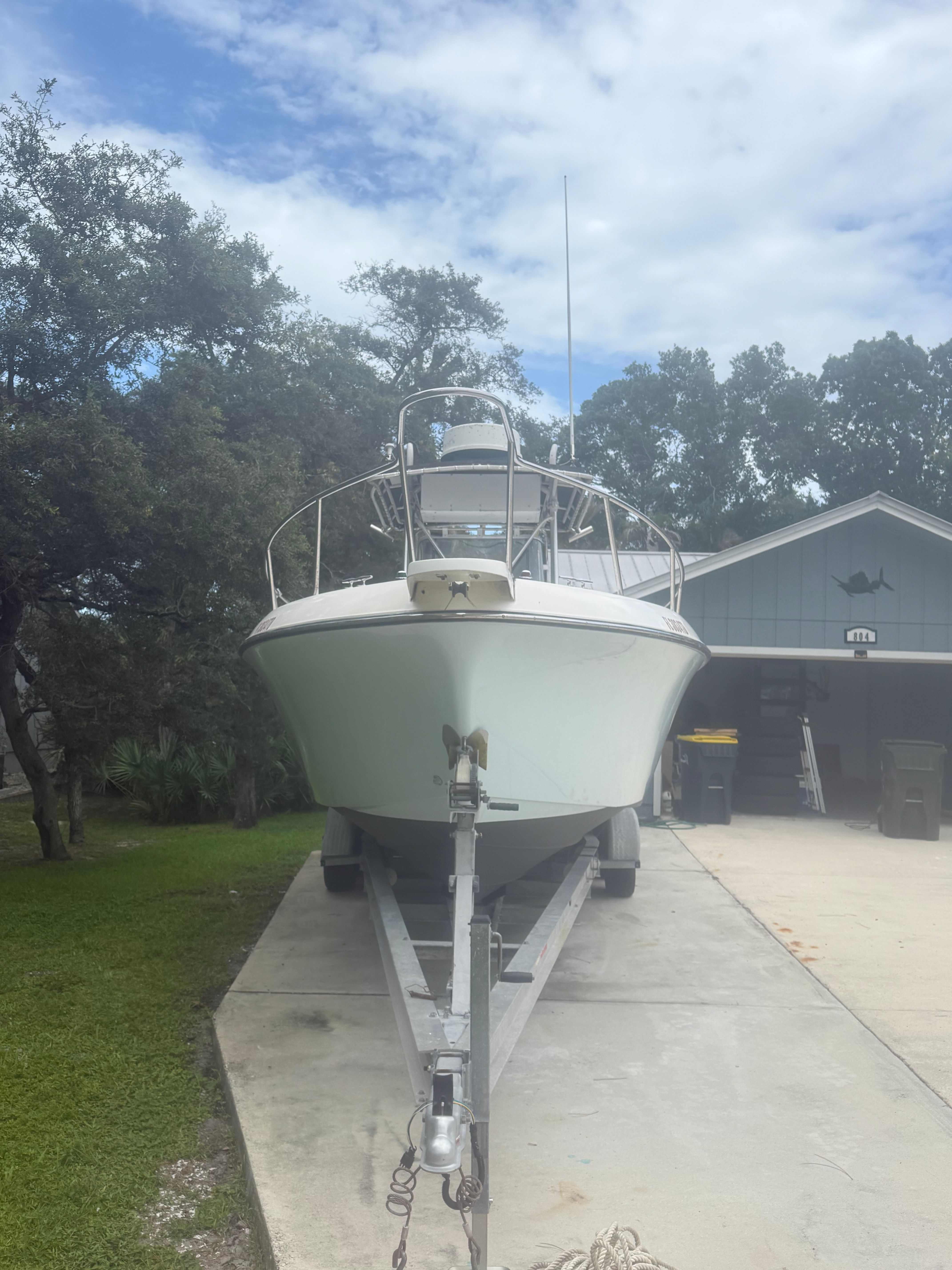 A 1994 Hydra-Sports Vector 2550 cc boat on a trailer in front of a garage.