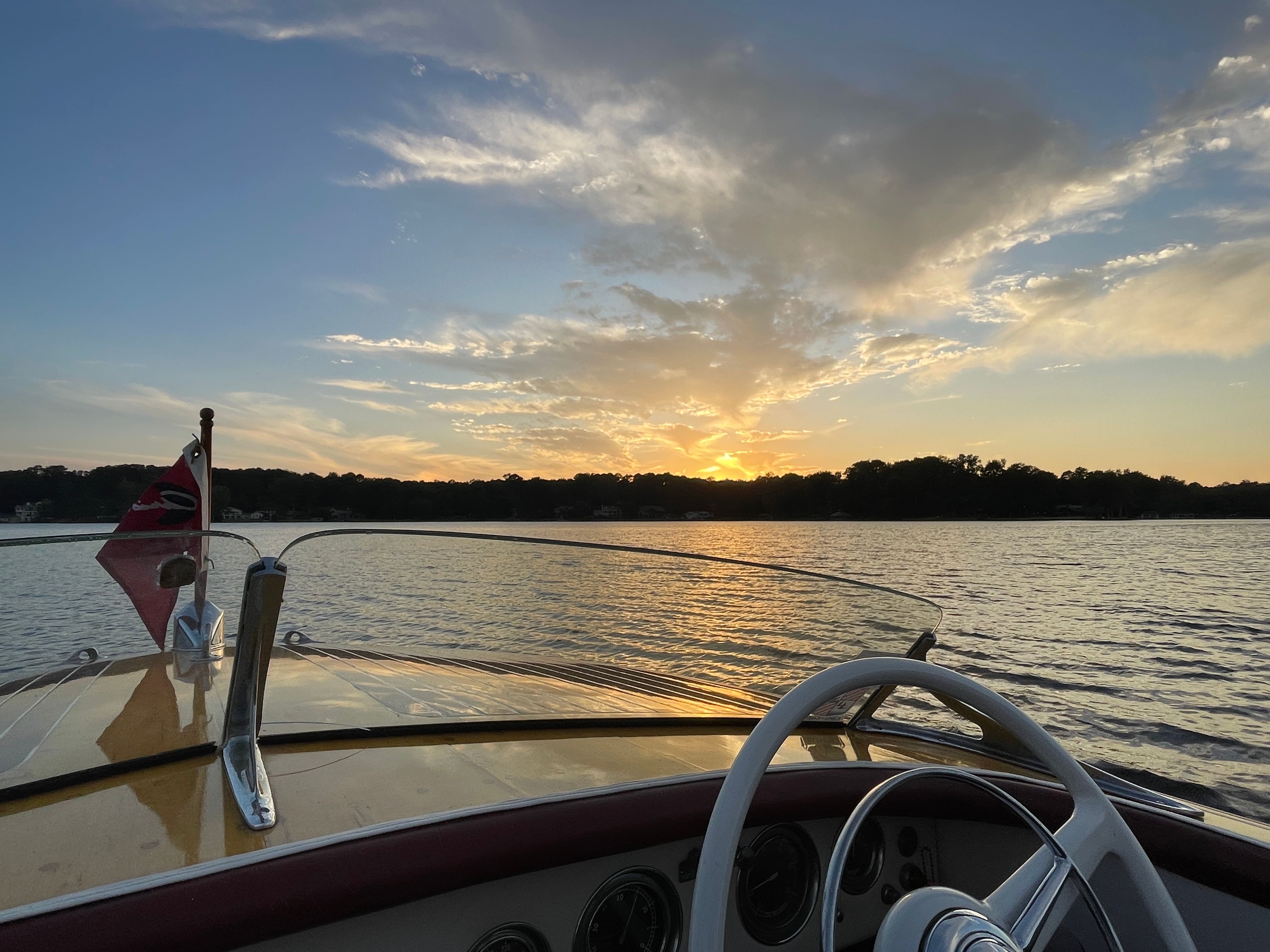 1954 Chris-Craft Riviera boat at sunset on the water.