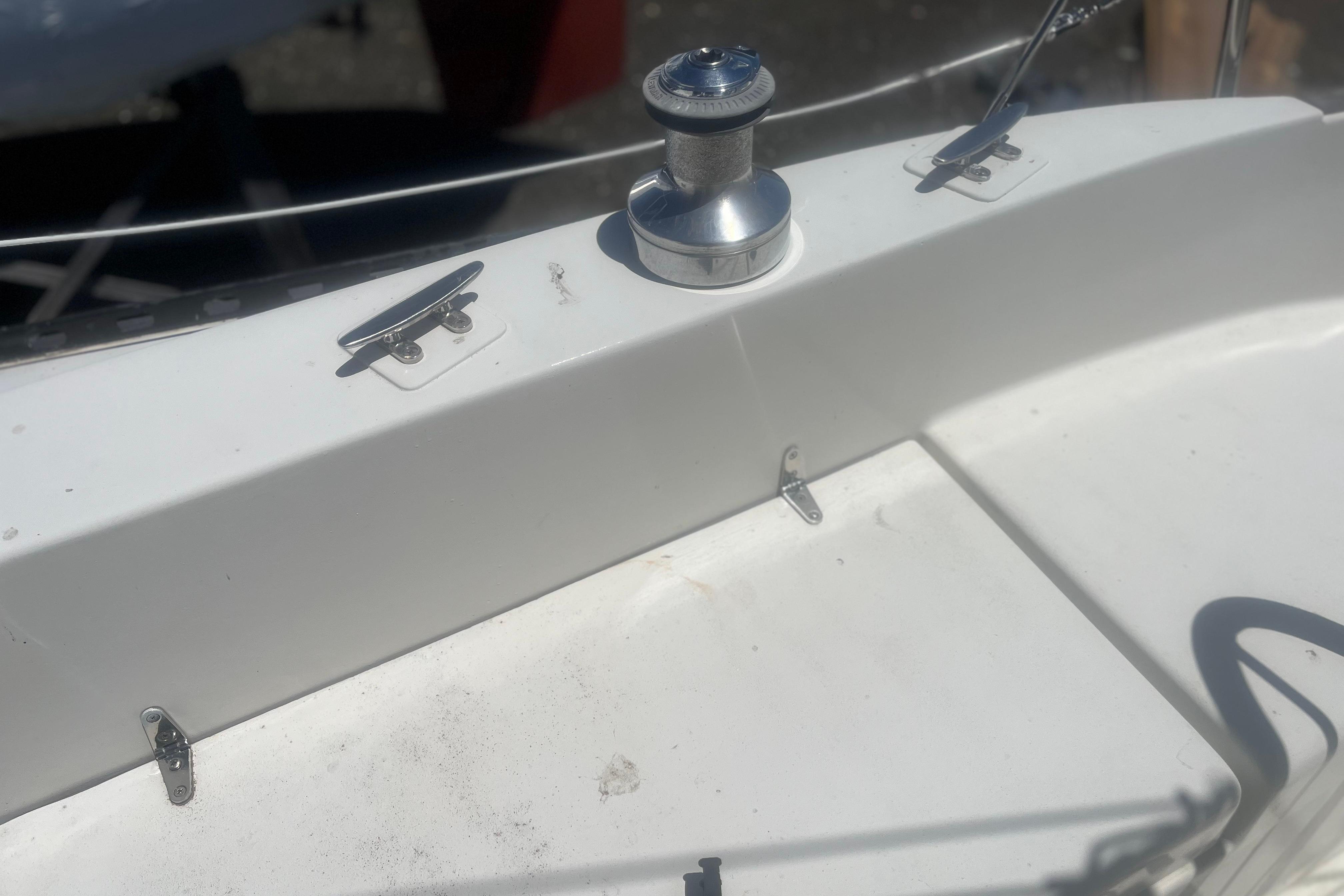 Deck of a 1972 C&C 30 sailboat featuring cleats and a winch.