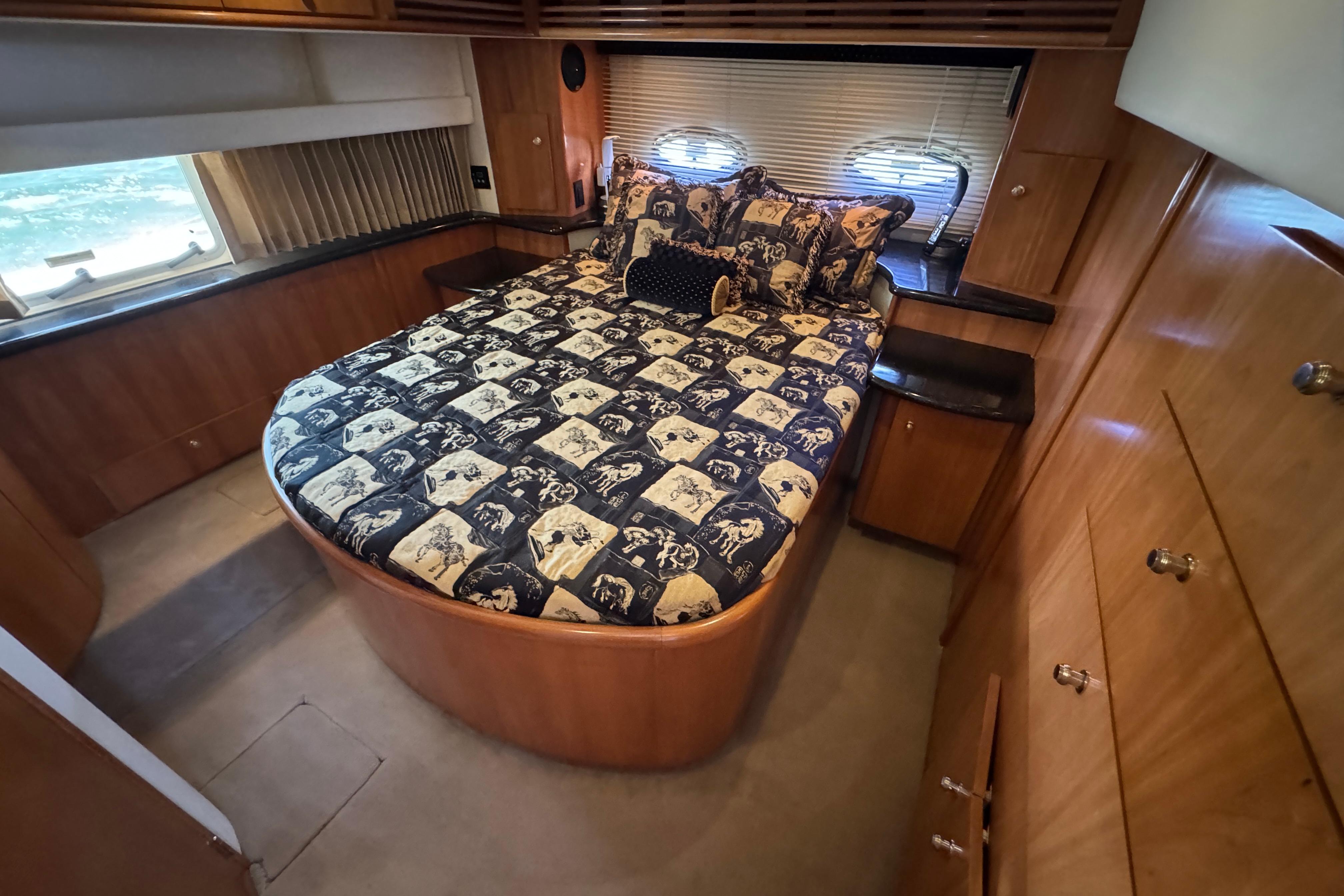 Luxurious bedroom interior of 2002 Carver 396 Motor Yacht with patterned bedding.