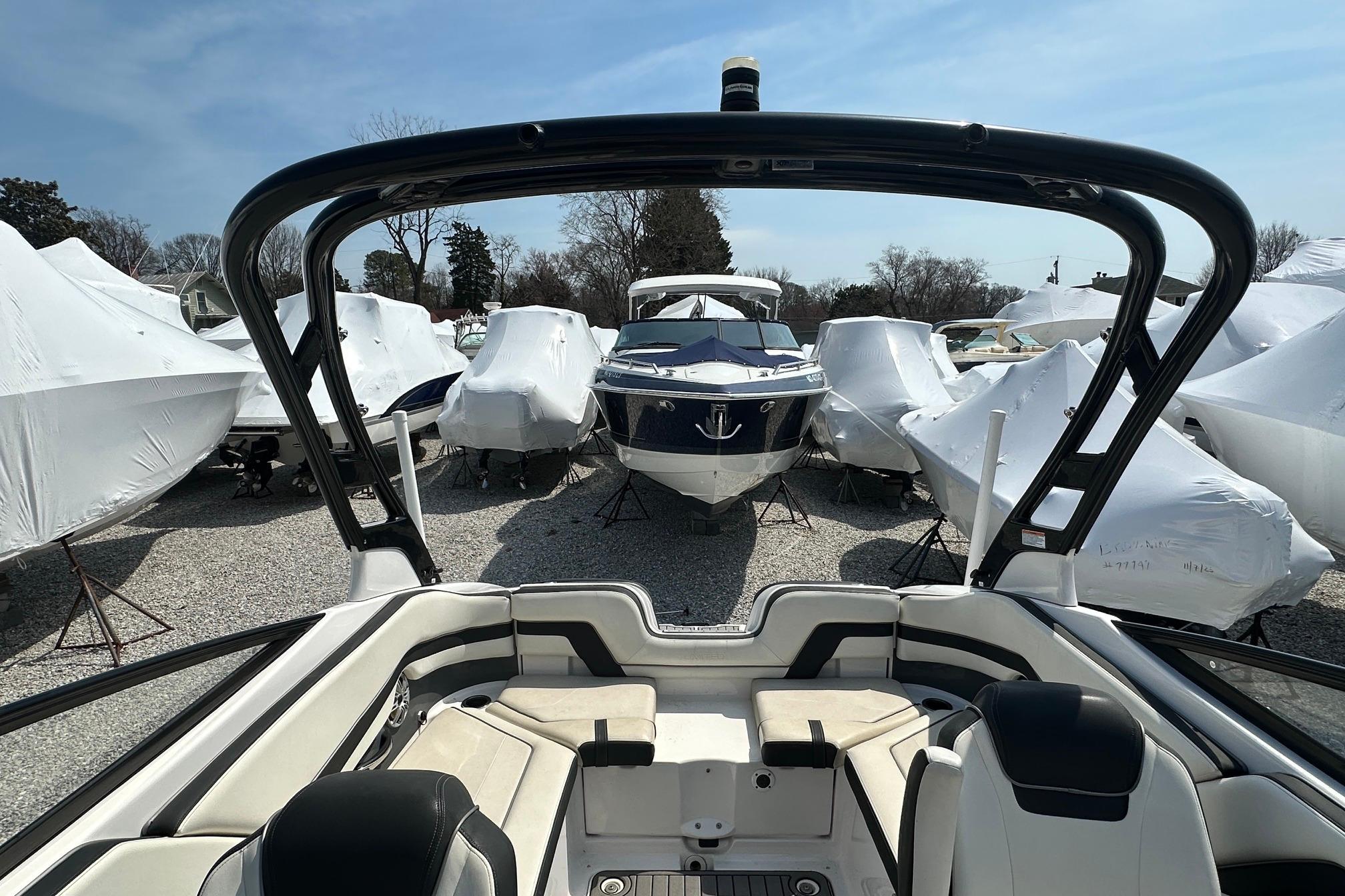 2016 Yamaha 242 Limited S boat in storage, surrounded by covered boats.