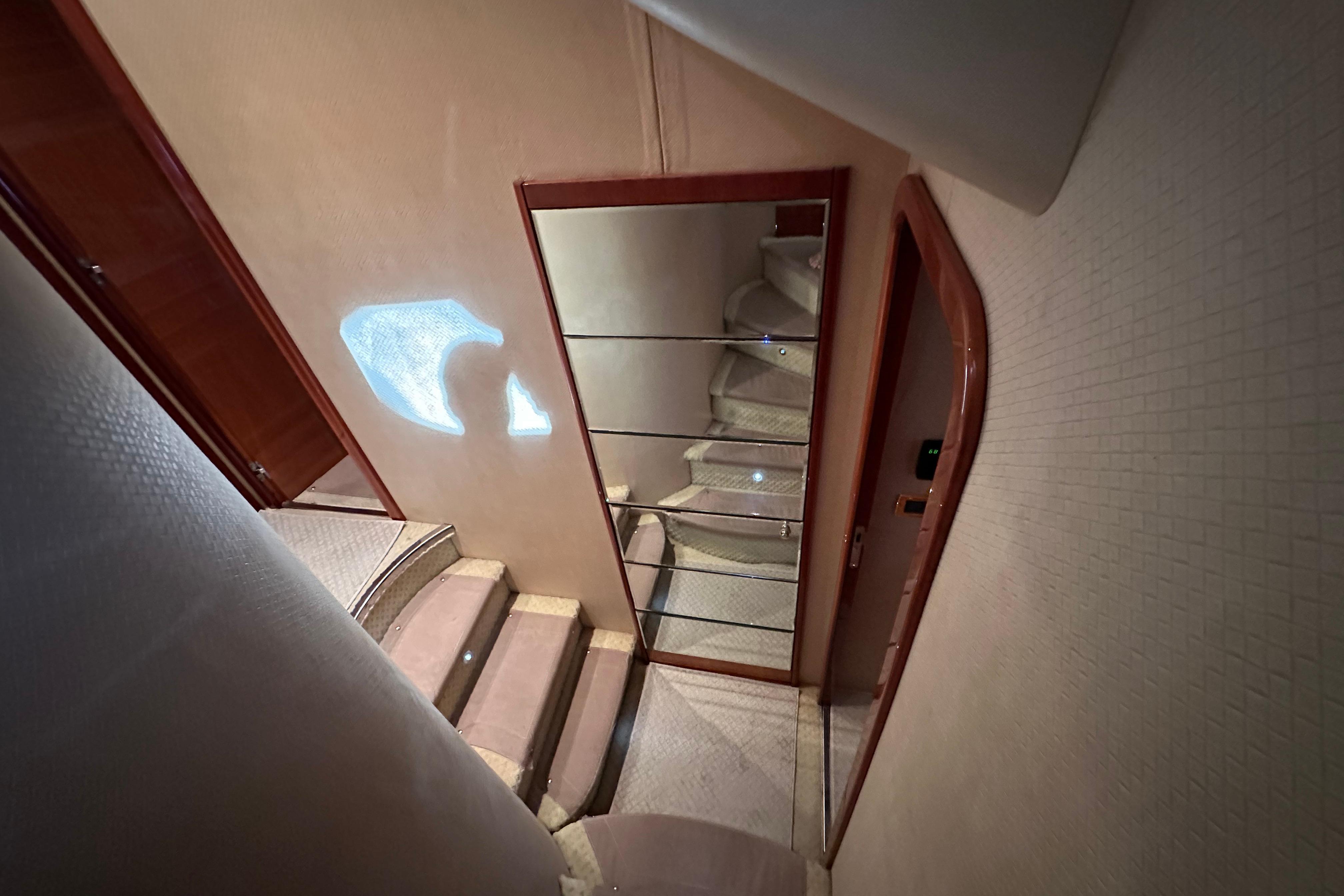 Interior staircase of 2004 Azimut 55E yacht with mirrored wall and elegant design.