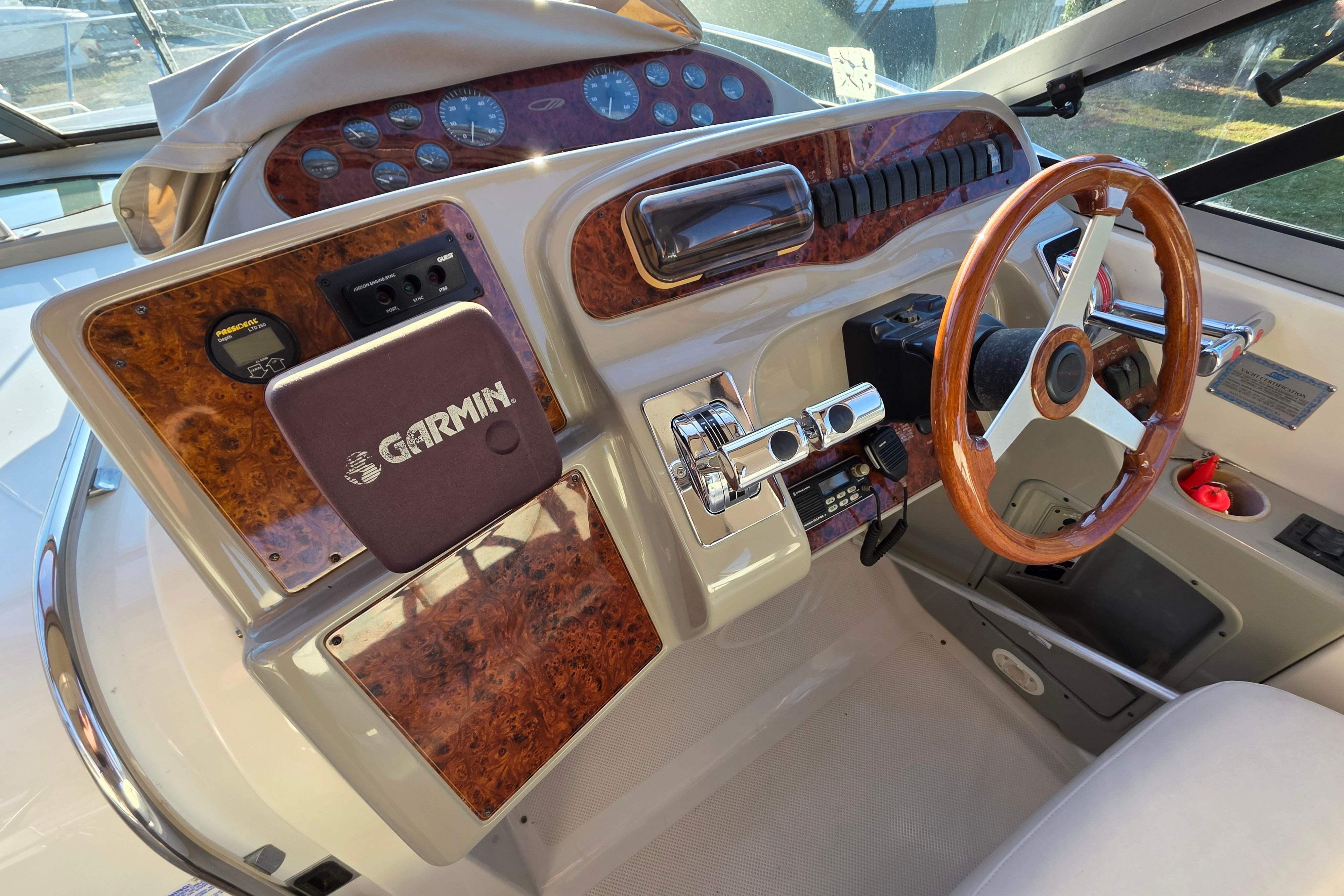 1998 Maxum 3700 SCR boat dashboard with Garmin navigation system and wooden steering wheel.