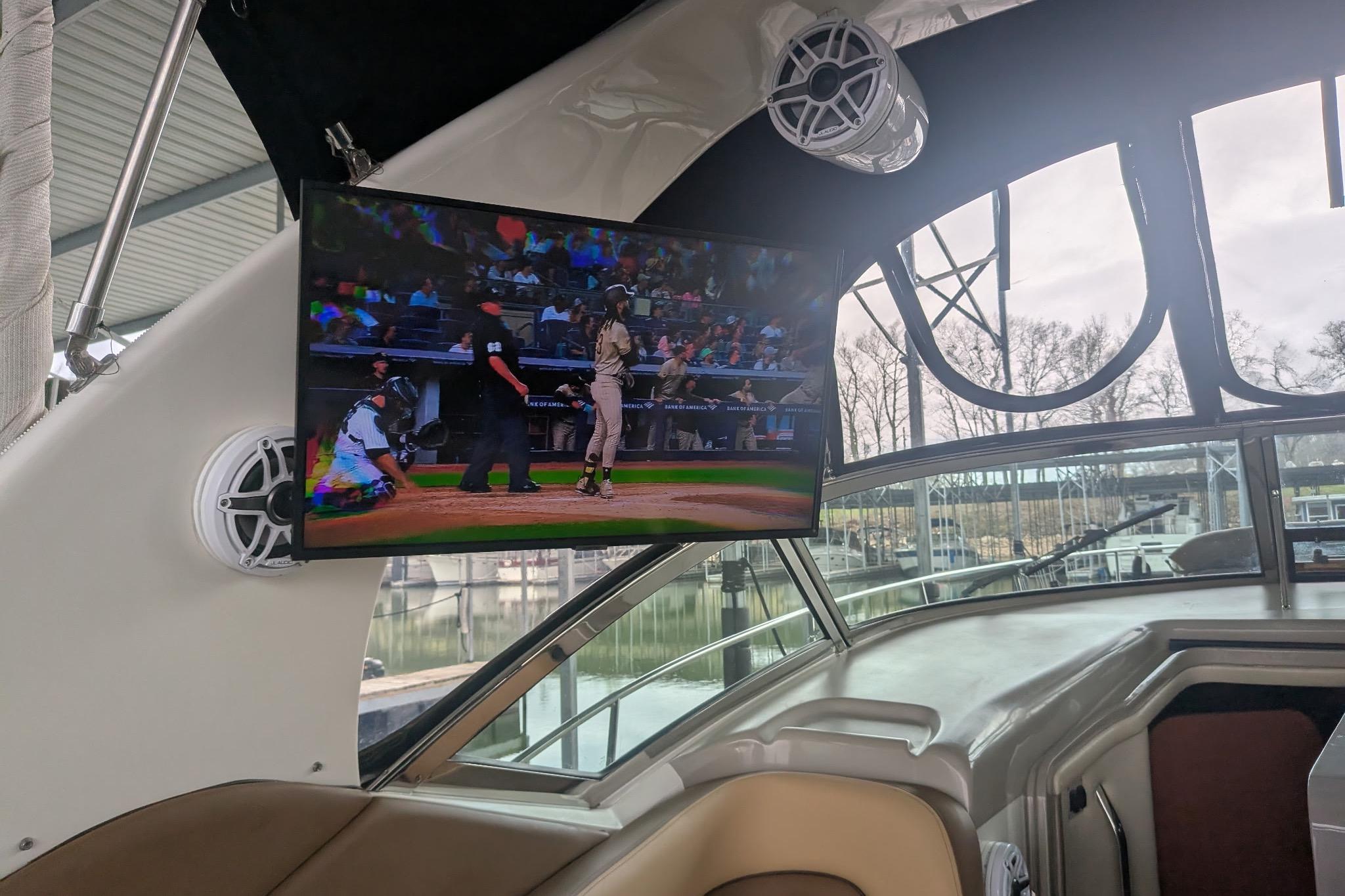 2002 Sea Ray Sundancer 320 interior with TV showing a baseball game, docked at marina.
