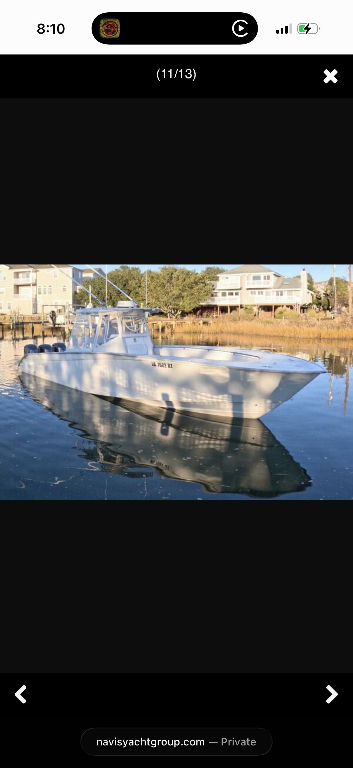 A 2007 Cape Horn 36T sits calmly on the water, surrounded by houses and trees.