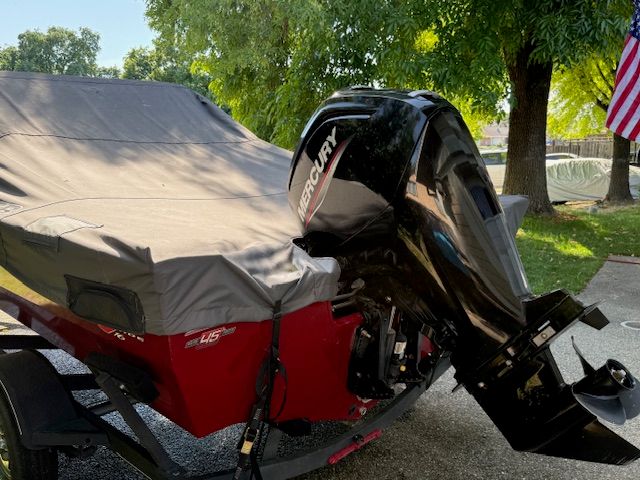 A 2023 Tracker PGV16WT 16 boat with a Mercury outboard motor, covered and on a trailer.
