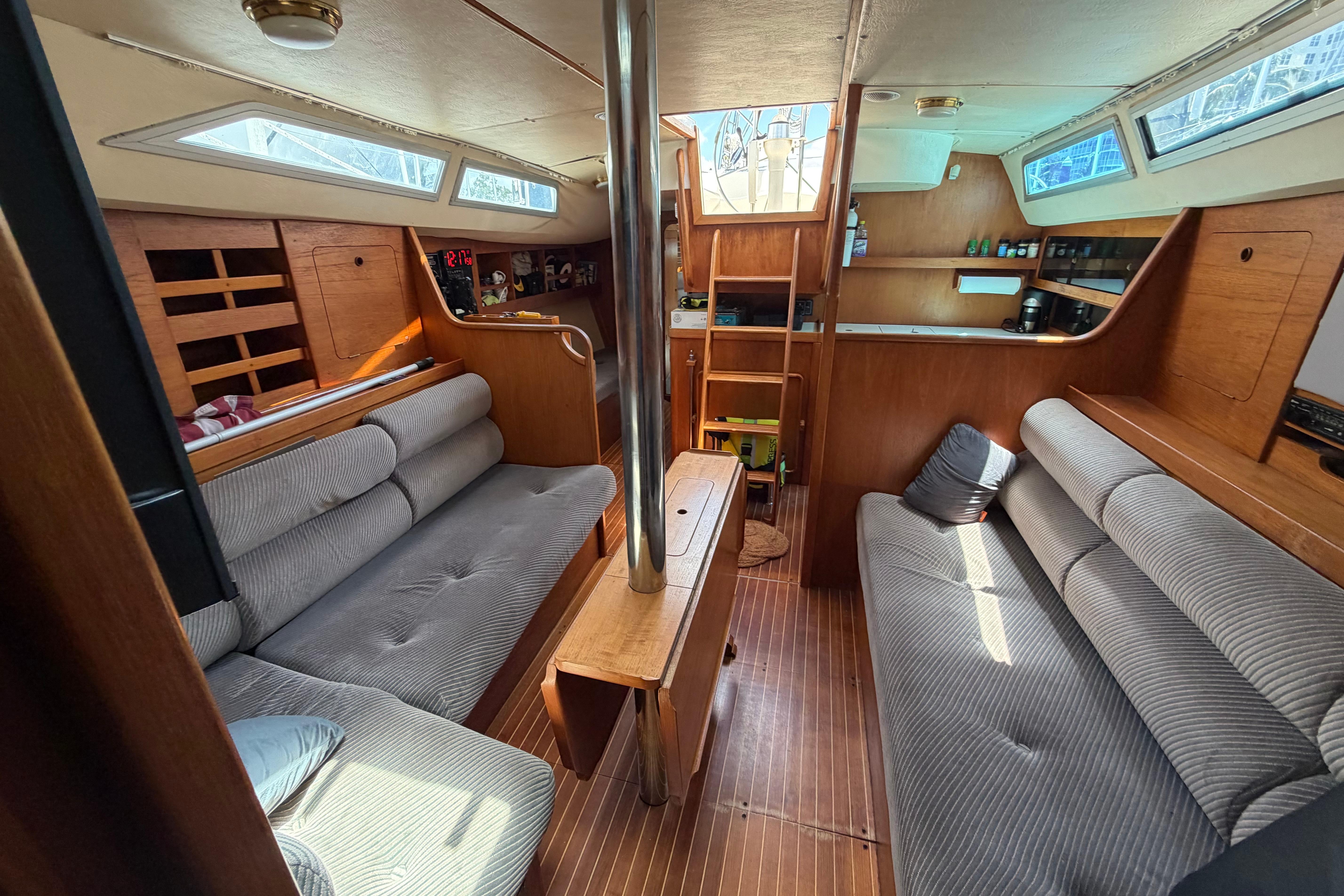 Interior of 1987 Moody 376 sailboat with cozy seating and wooden finishes.