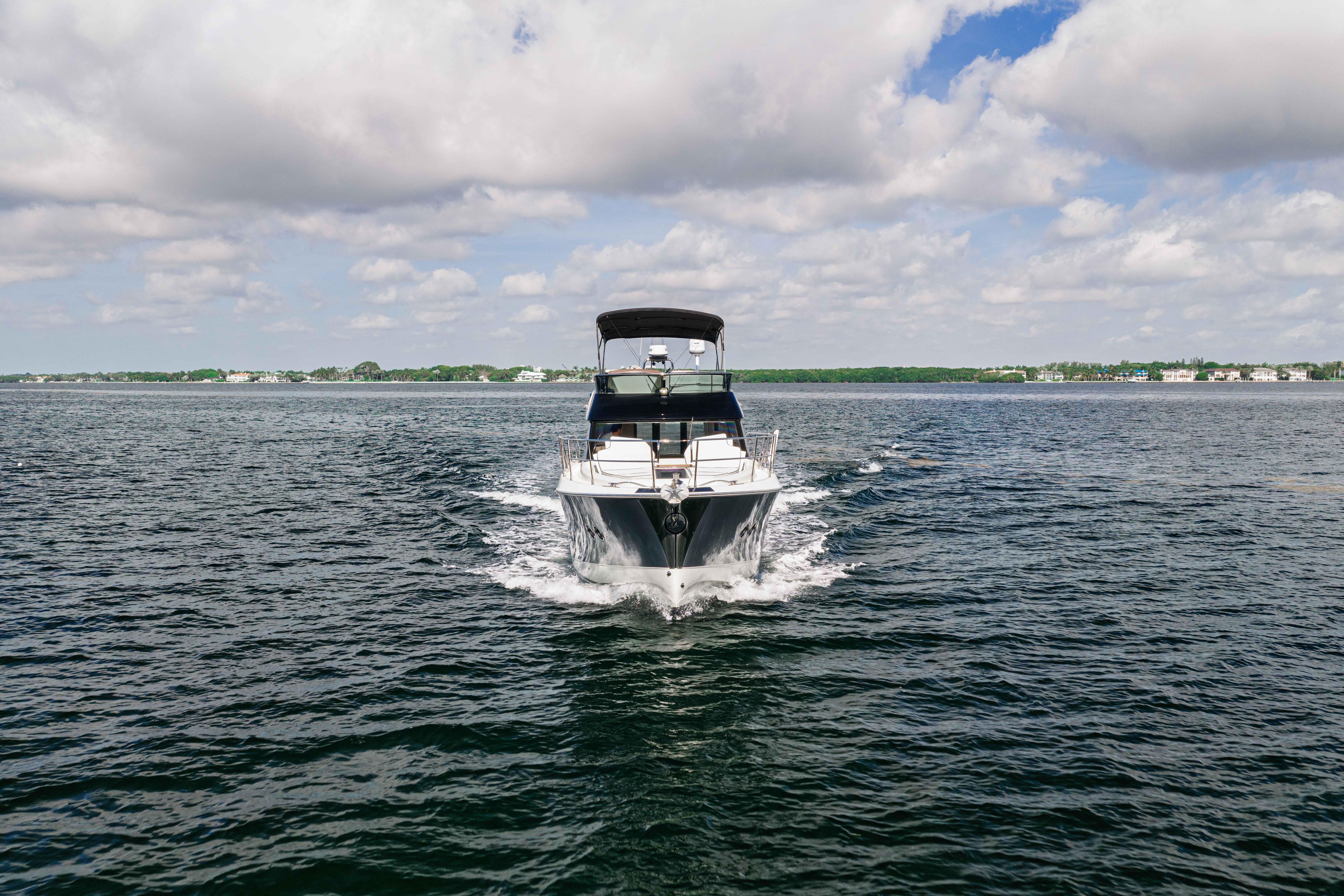 2017 Monte Carlo Yachts MC5 cruising on open water under a partly cloudy sky.