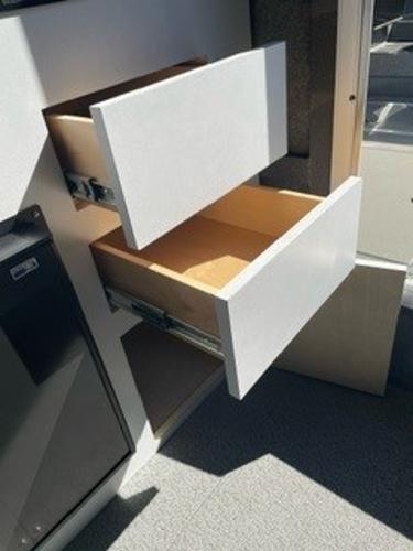 Open white drawers in a Spartan 2600 Olympia, 2025 model, showcasing interior storage space.