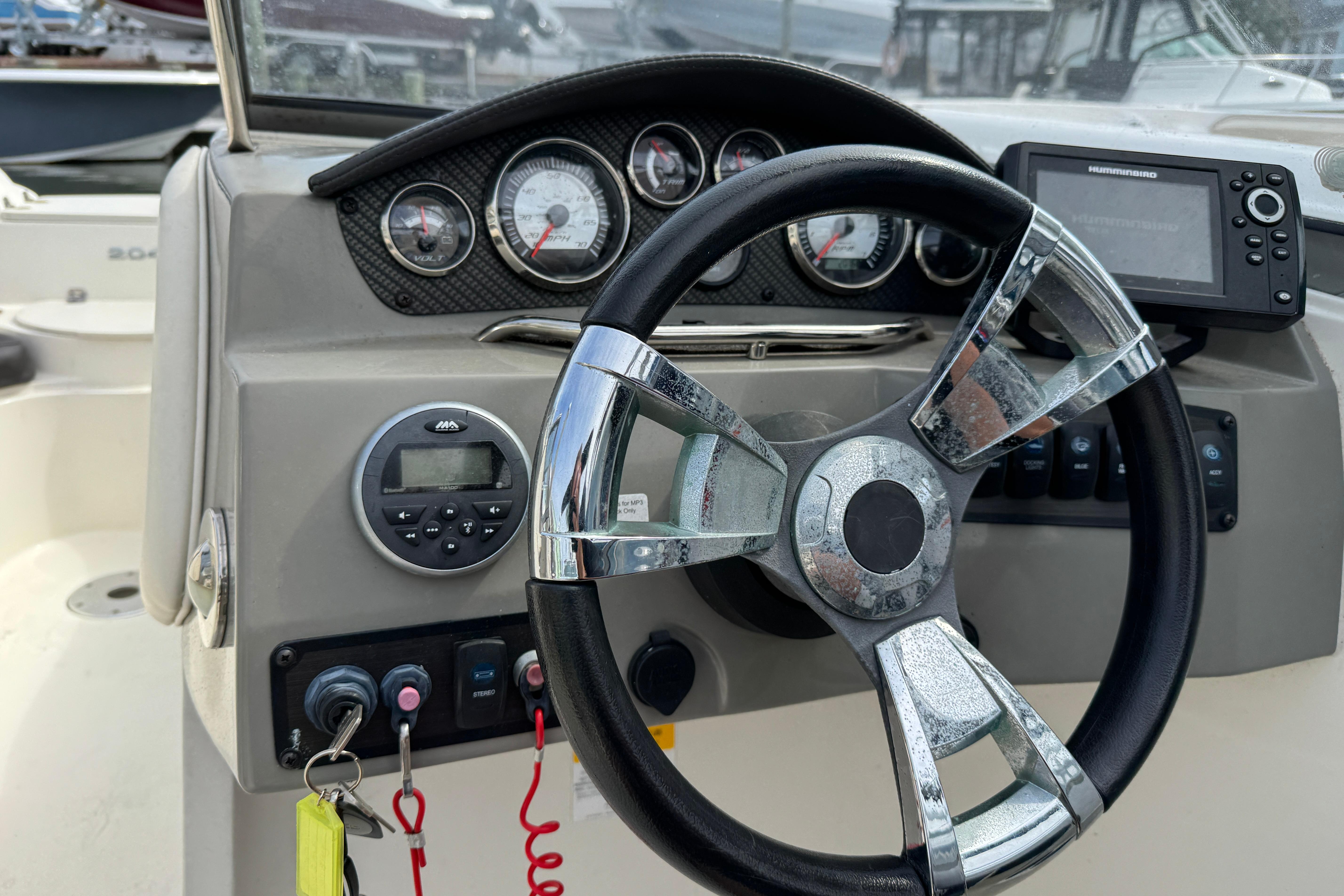 Steering wheel and dashboard of 2018 Stingray 204 LR boat with gauges and controls.