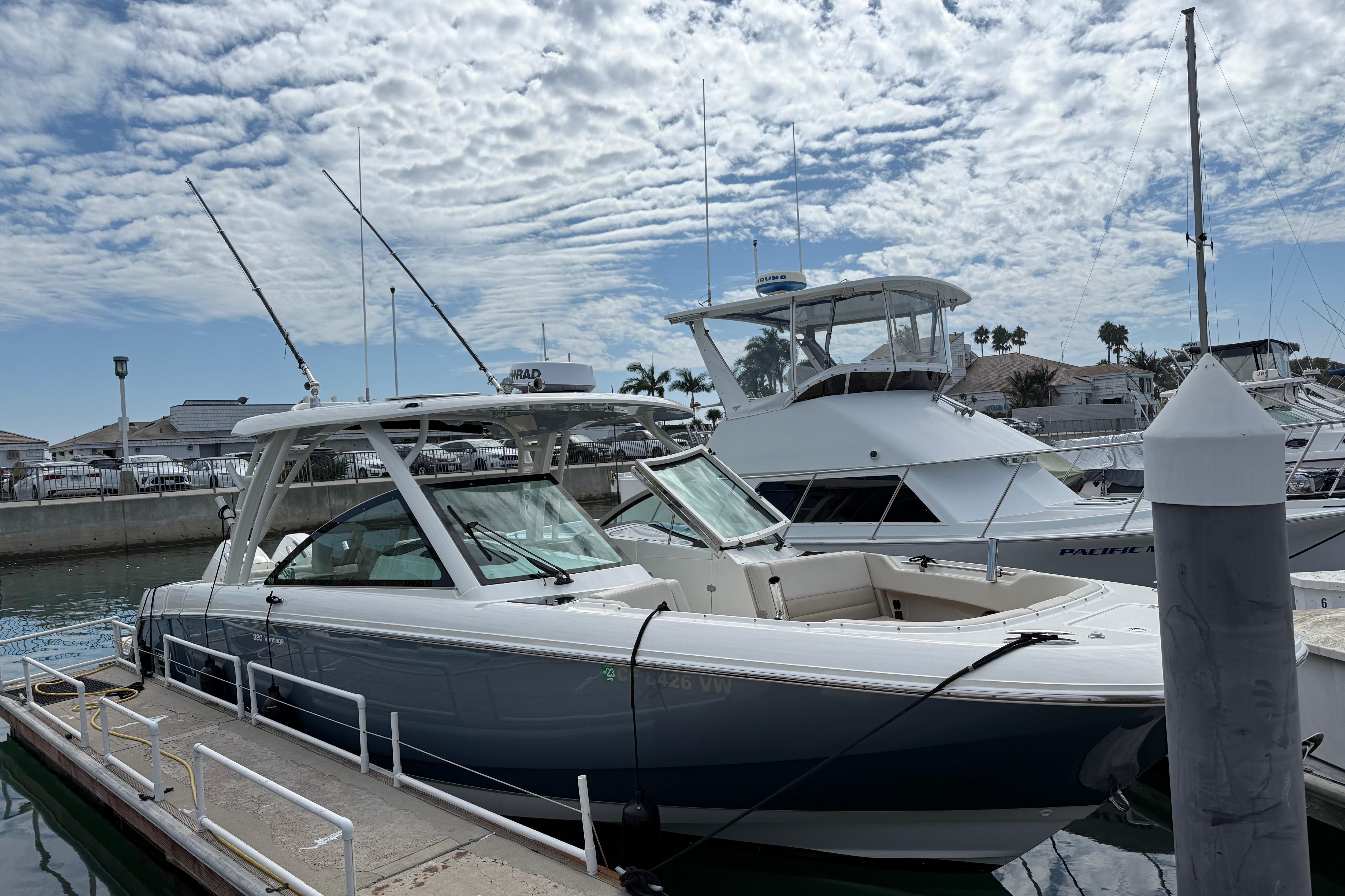 2023 Boston Whaler 320 Vantage docked at marina under cloudy sky.
