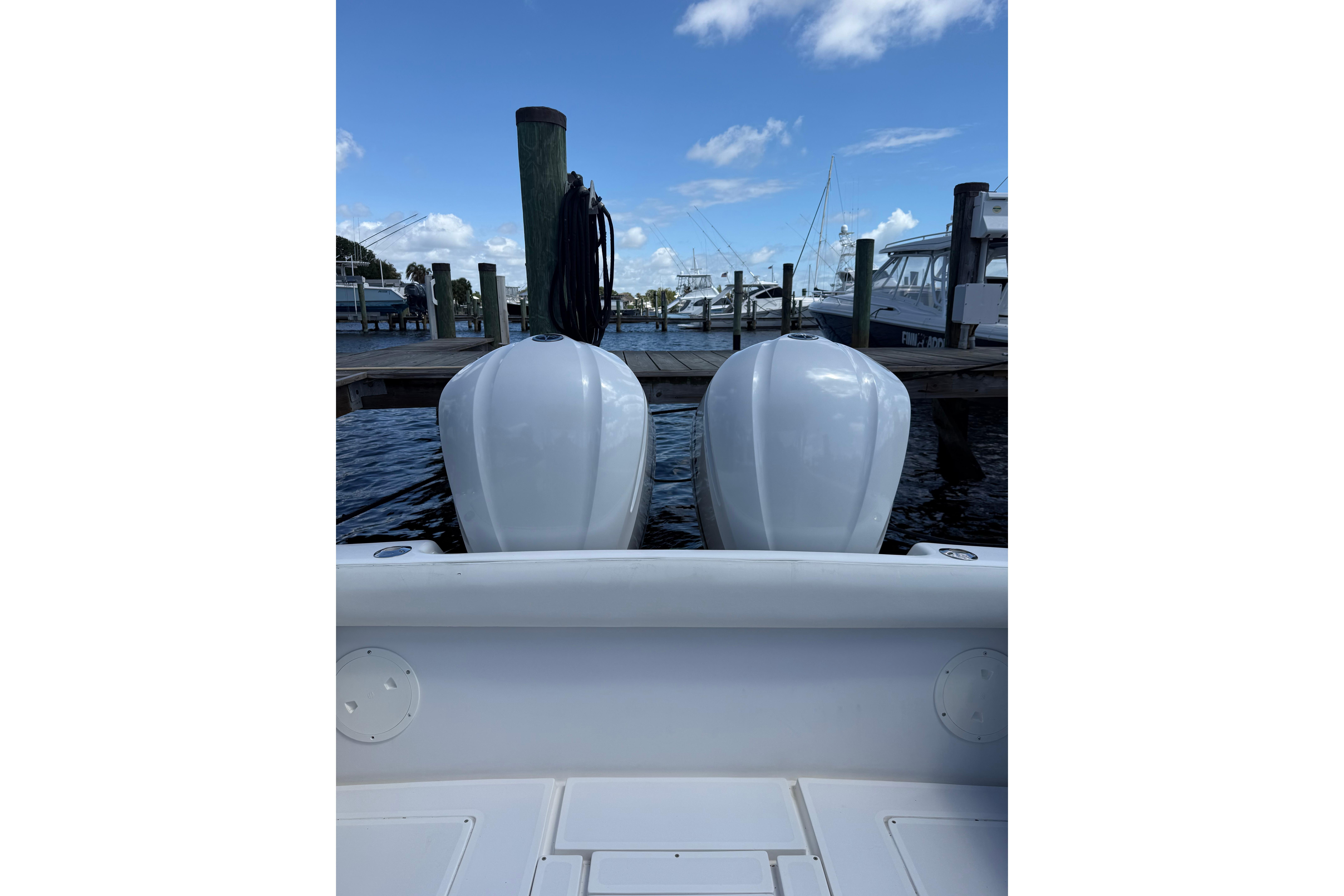 Twin outboard engines on a 1992 Intrepid 289 Center Console at a marina dock.