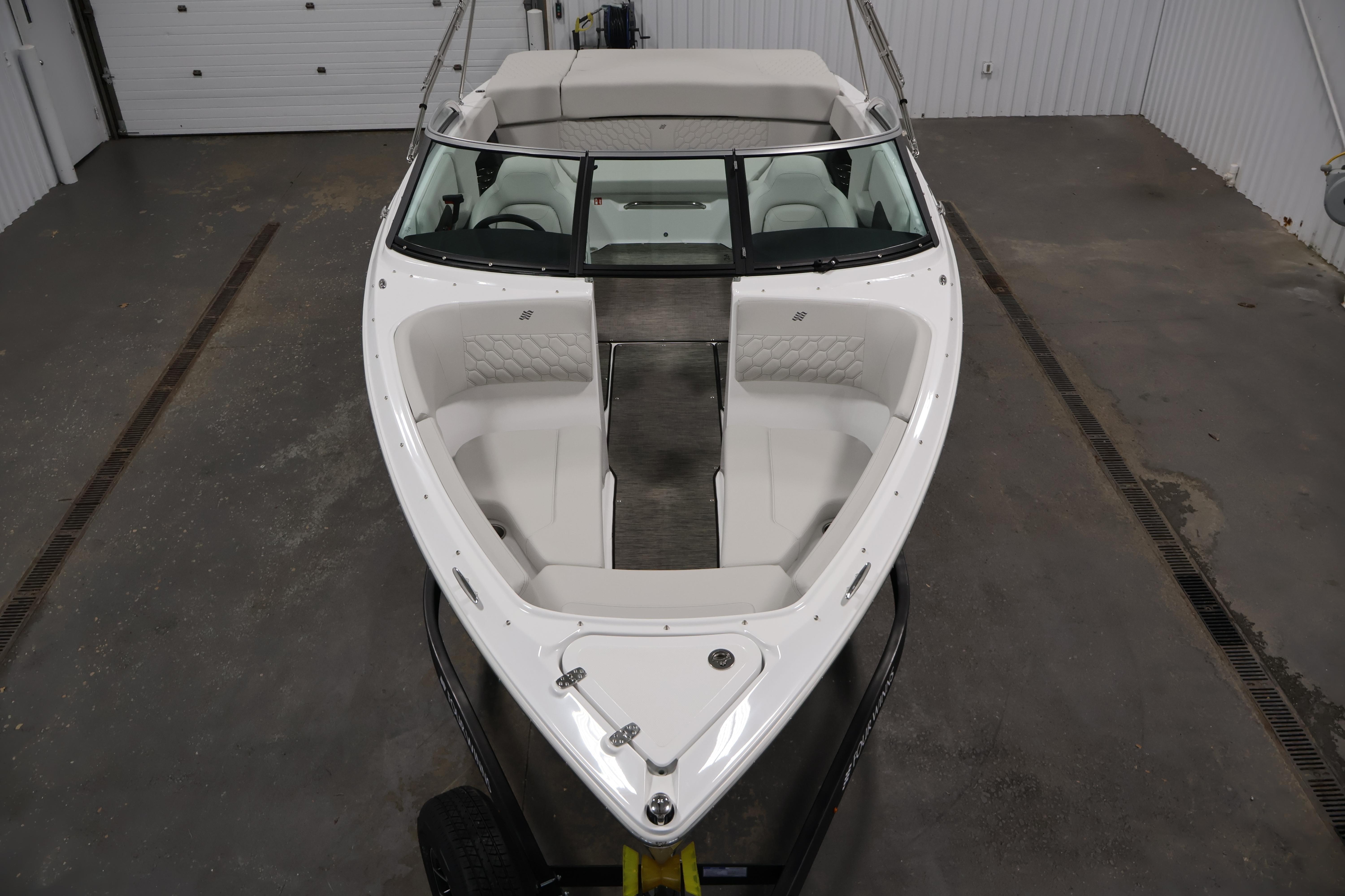 2026 Four Winns H4 Freedom boat in a garage, showcasing sleek design and spacious seating.