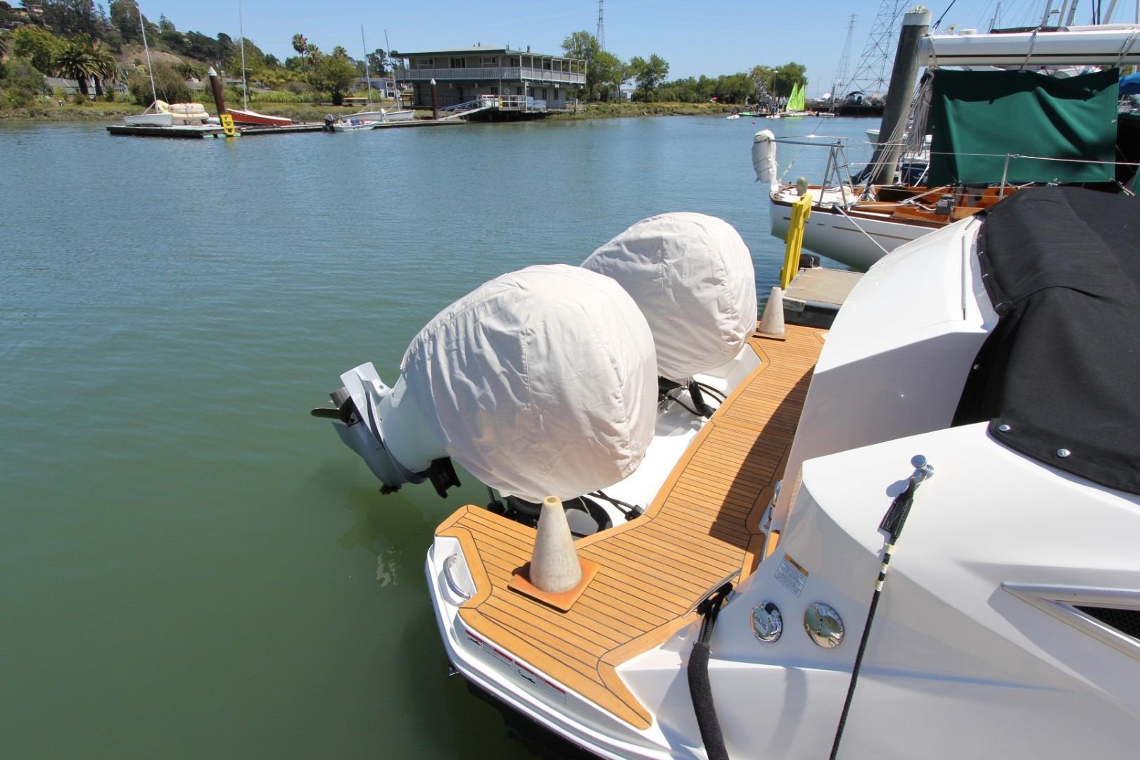 2021 Sea Ray Sundancer 320 Outboard docked, featuring covered engines and sleek design.