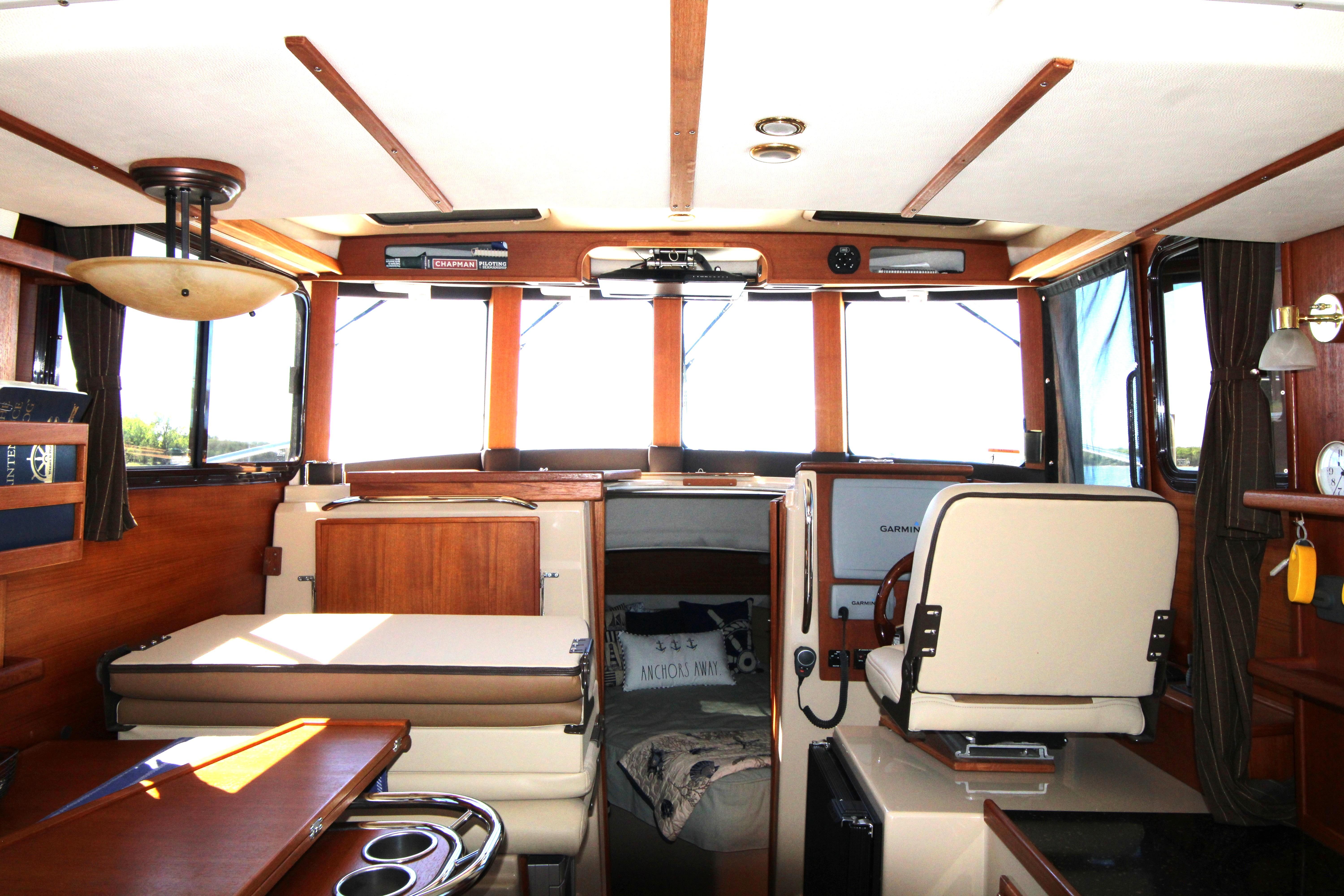Interior of 2013 Ranger Tugs R-31 CB boat with helm, seating, and wooden accents.