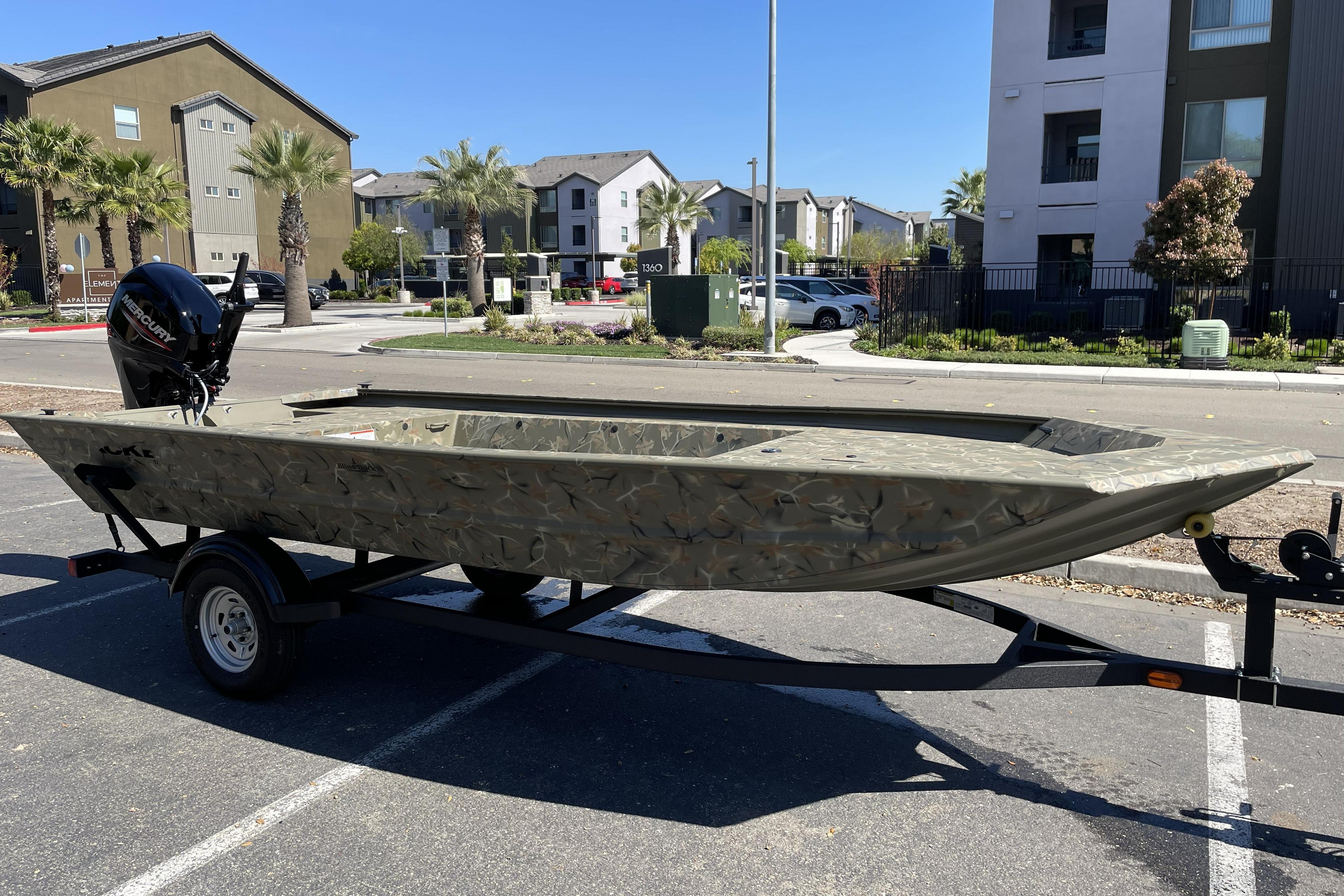 2025 Tracker Grizzly 1754 Jon boat on trailer in urban setting.