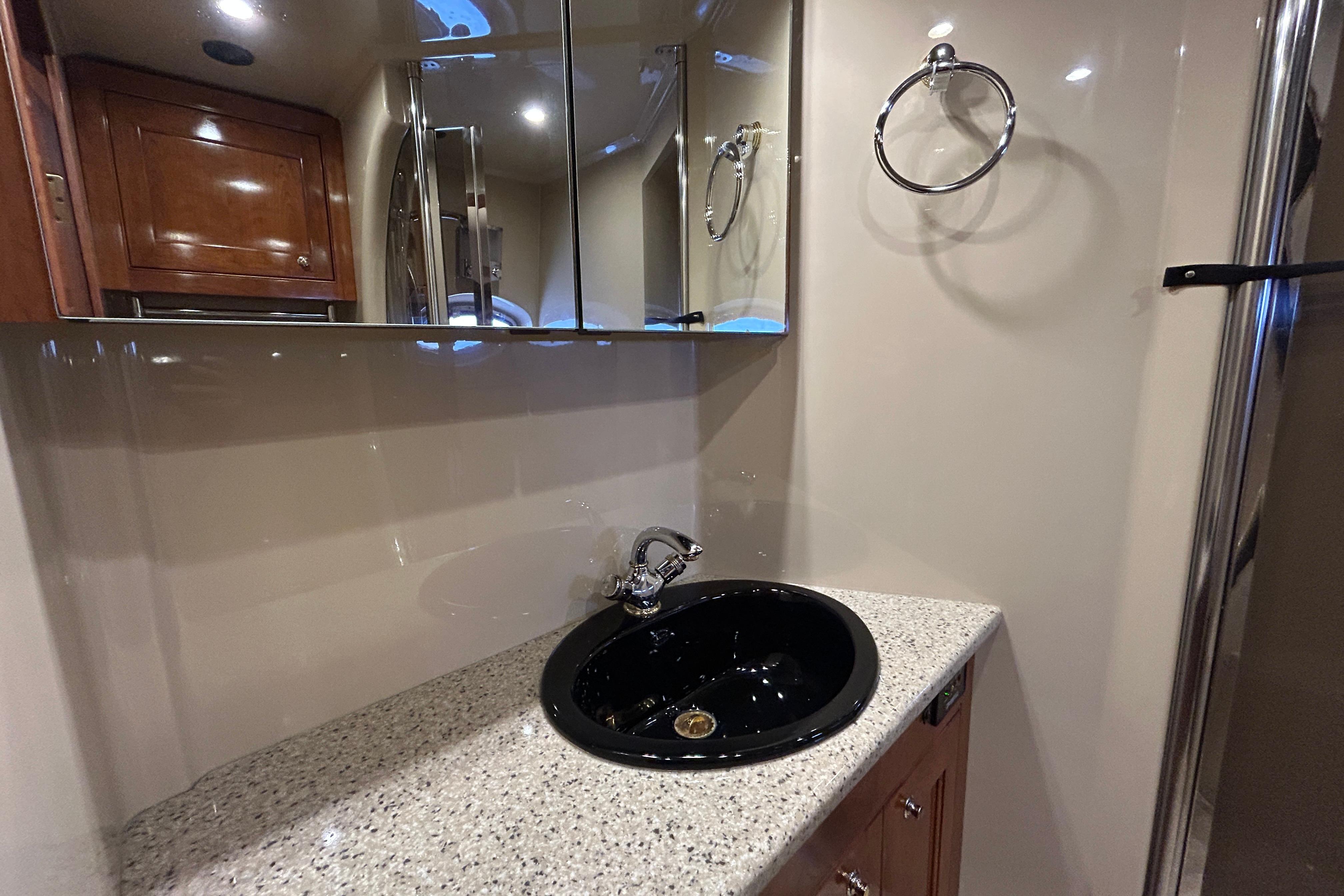 2003 Cruisers Yachts 540 Express bathroom with black sink and mirrored cabinet.
