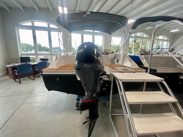 2026 Starcraft SVX 171 boat with outboard motor in showroom, featuring sleek design and modern amenities.
