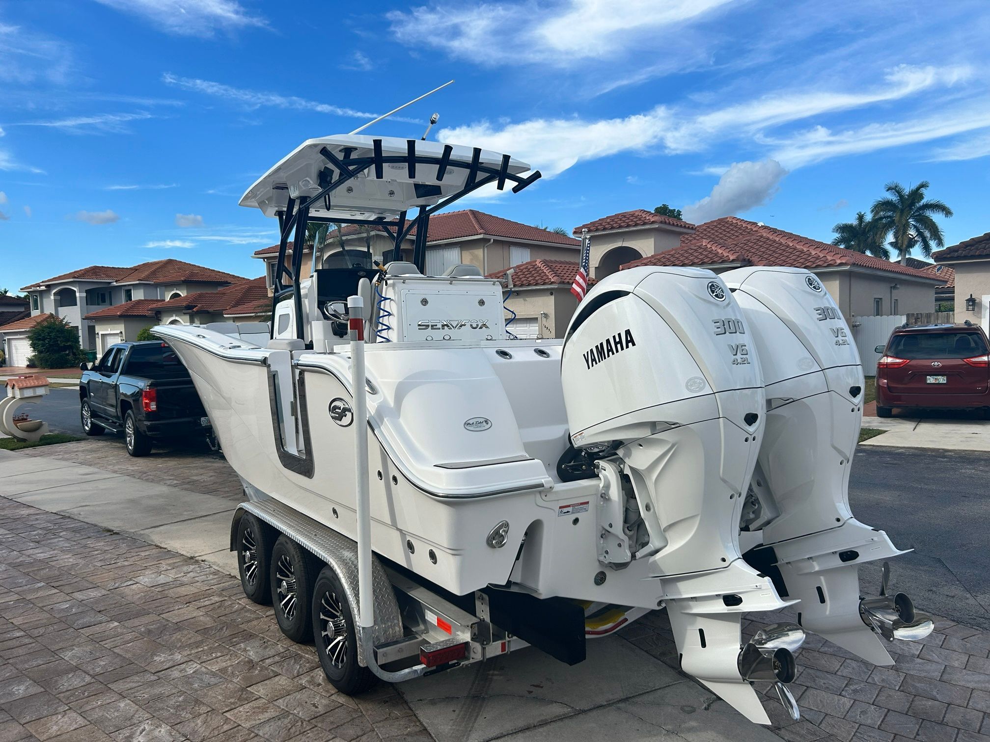 2023 Sea Fox 288 Commander with twin Yamaha engines, on a trailer in a residential area.