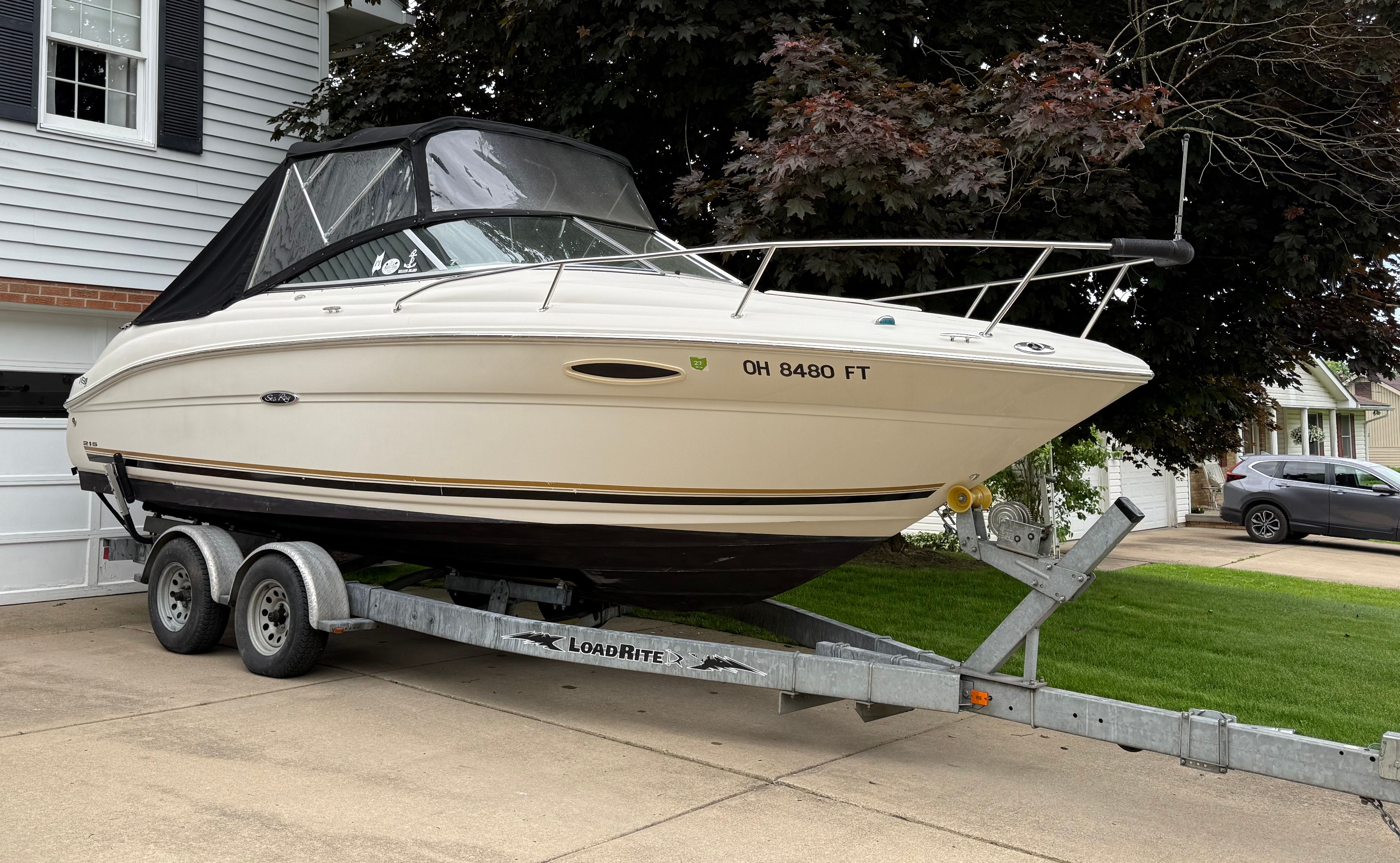 2006 Sea Ray 215 Weekender on trailer in driveway.