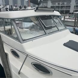 A 2001 Sport-Craft 272 boat docked at a marina. It features a white deck and large windows.