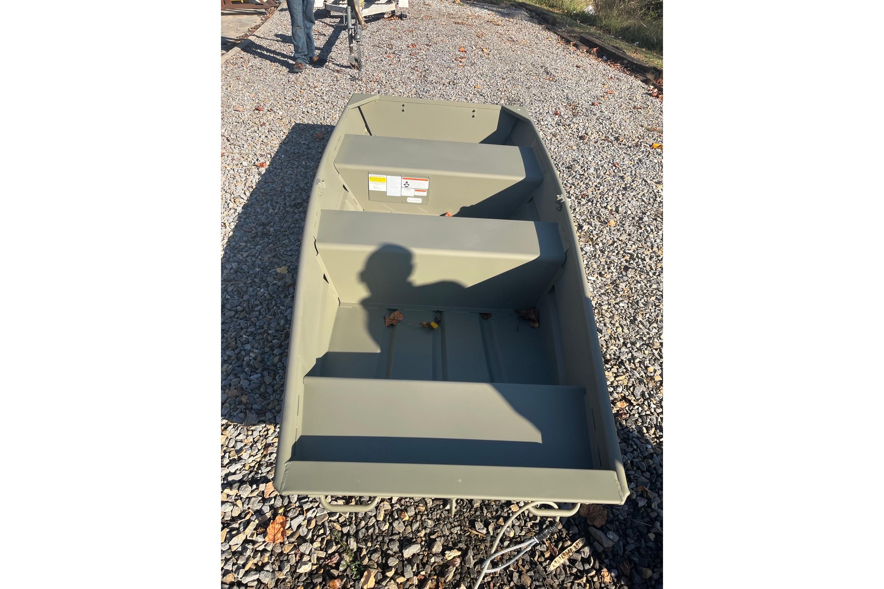 2025 Tracker Grizzly 10 Jon boat on gravel, shadow visible inside.