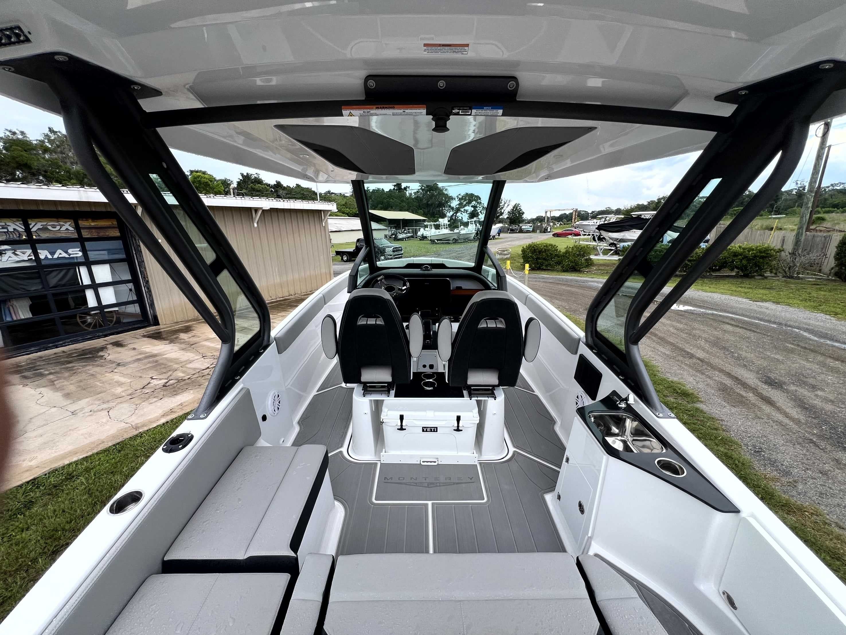 The image shows the cockpit of a Monterey Elite 25 boat with modern seating and a helm station.