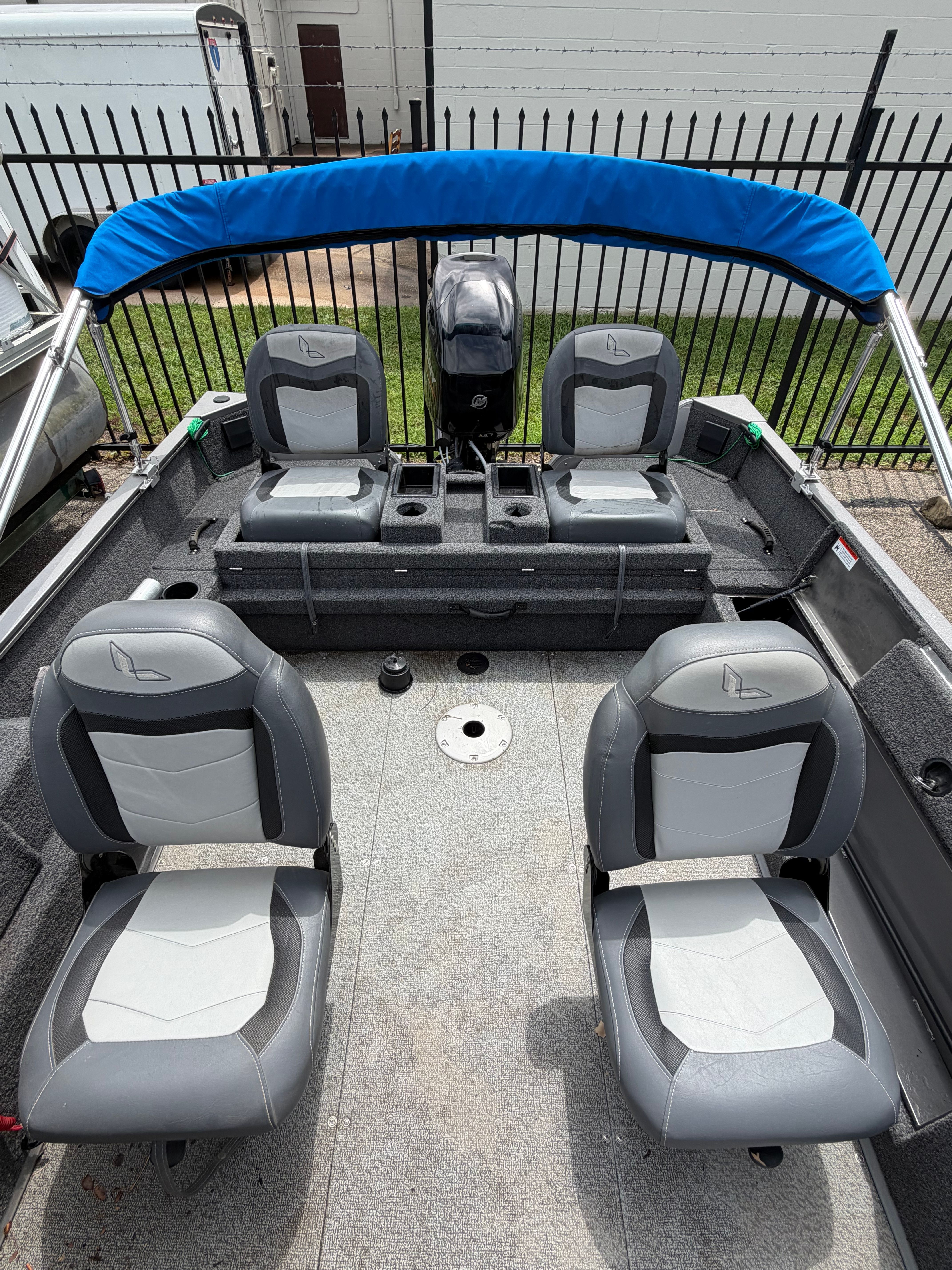 The image shows the interior of a Lowe Fishing Machine 1675SC boat with four gray seats.