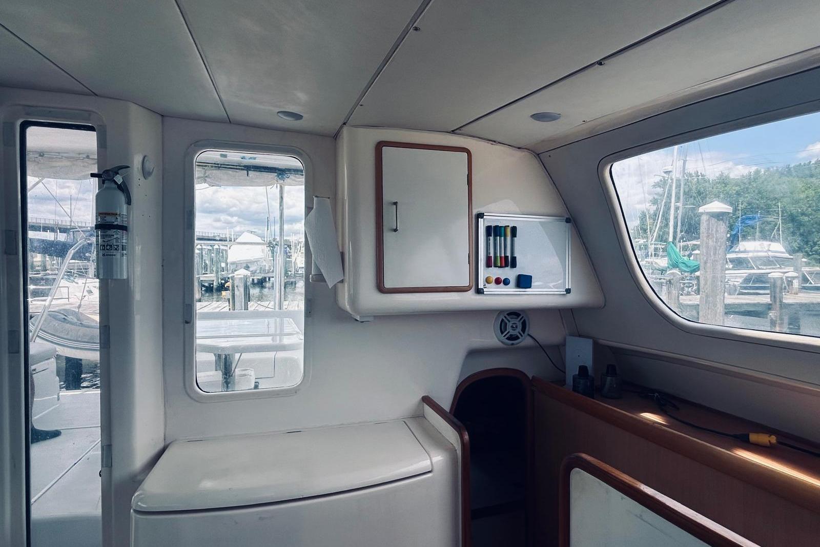 Interior of a 2001 Robertson & Caine Leopard yacht with marina view through windows.
