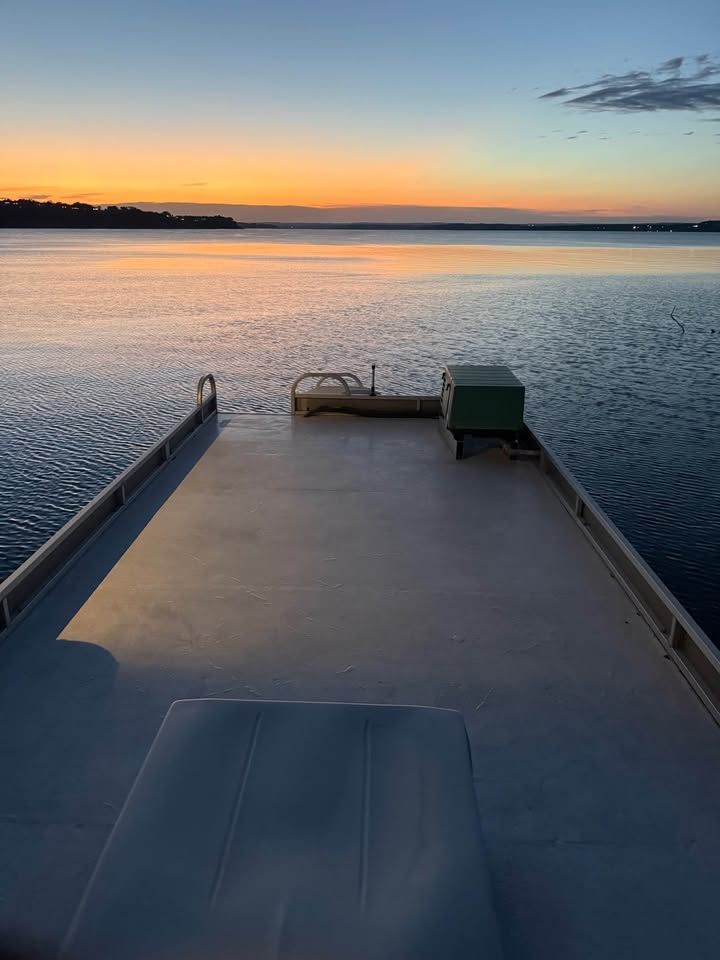 Pontoon boat at sunset on calm water, Sun Tracker 2008.