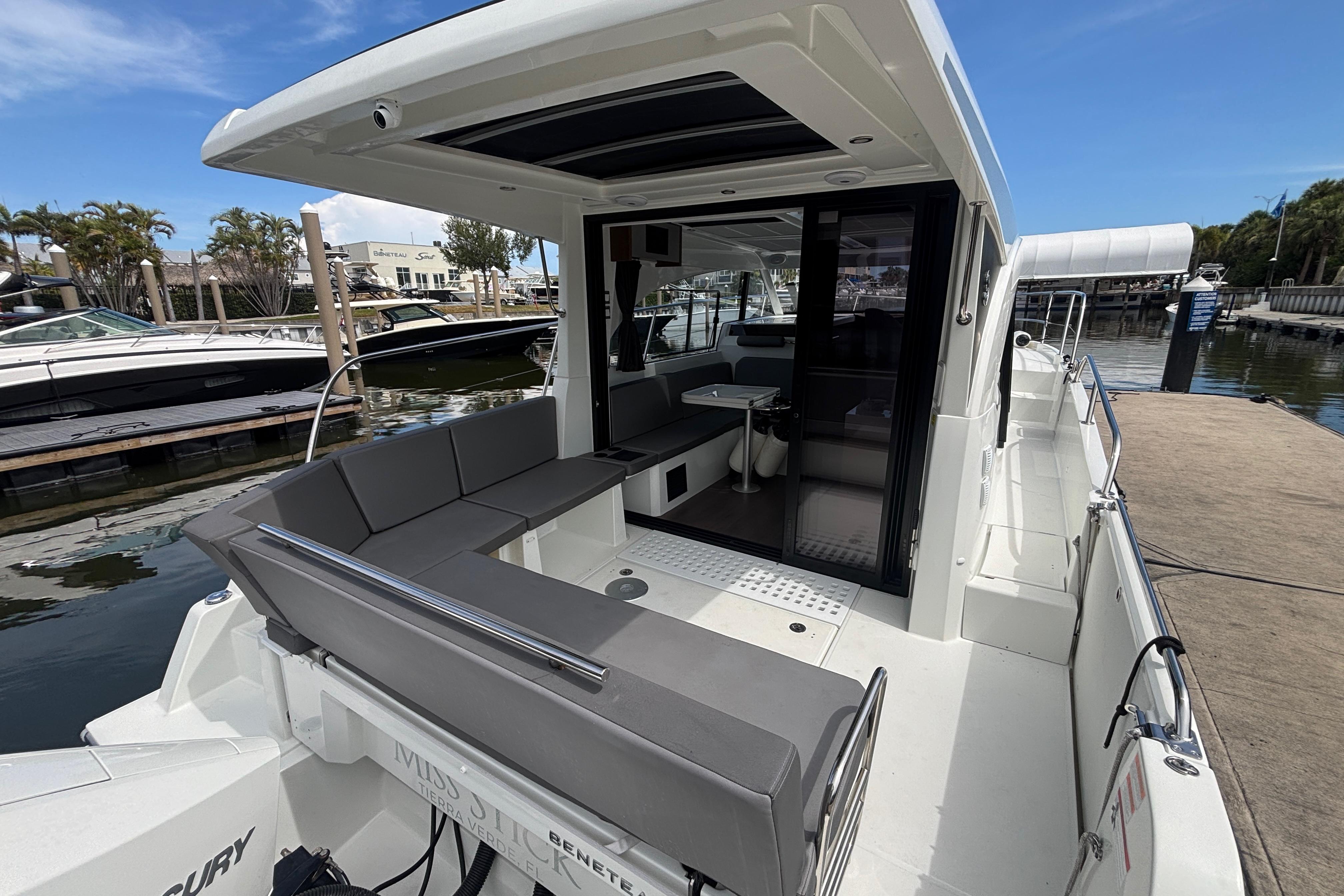 2024 Beneteau Antares 11 boat interior with seating and table, docked at marina.