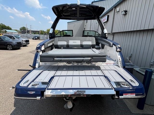 2026 Chaparral SSX 6 boat with open deck, parked outdoors near a building.