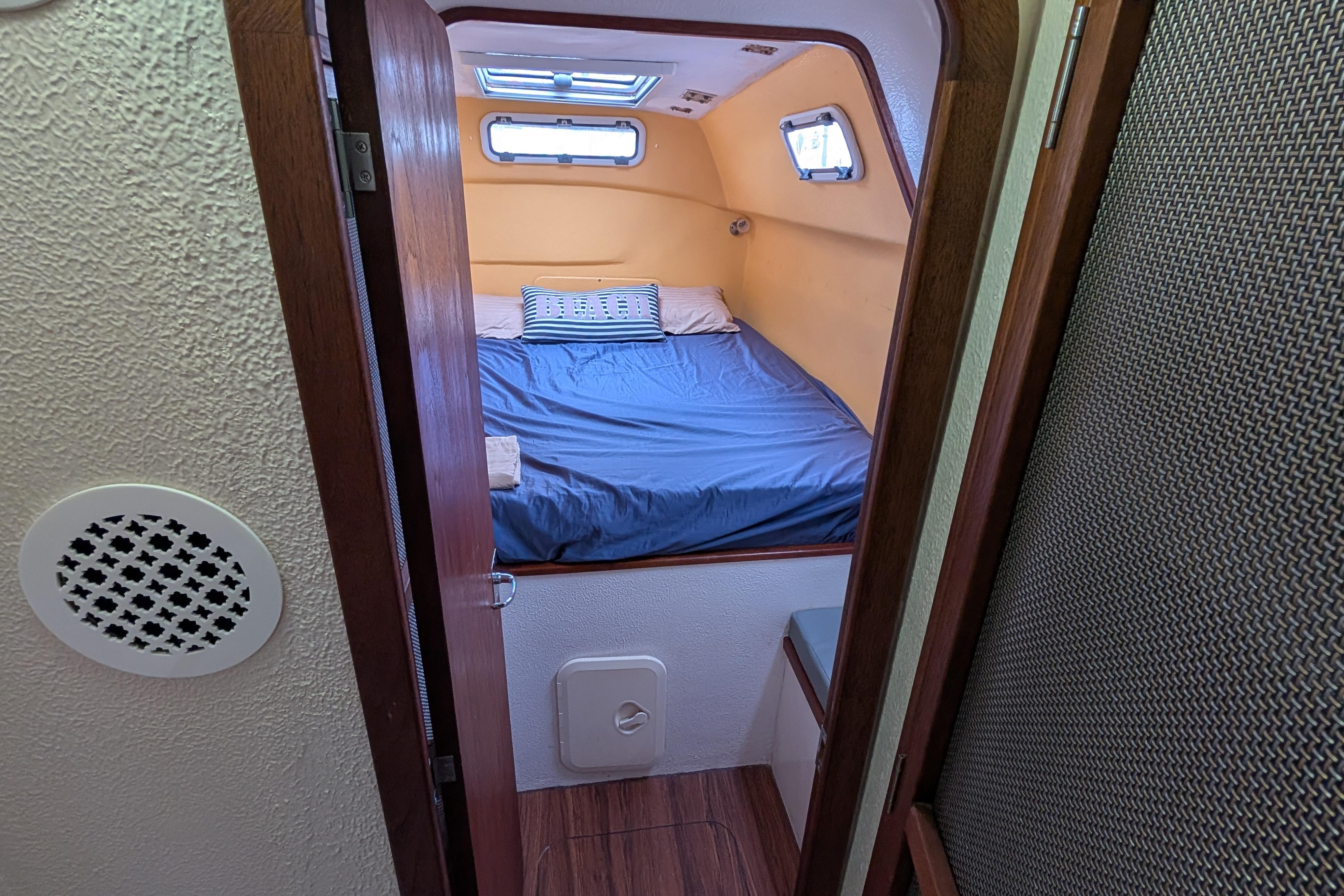 Cozy cabin interior of 1999 Island Spirit 37 yacht with bed and portholes.