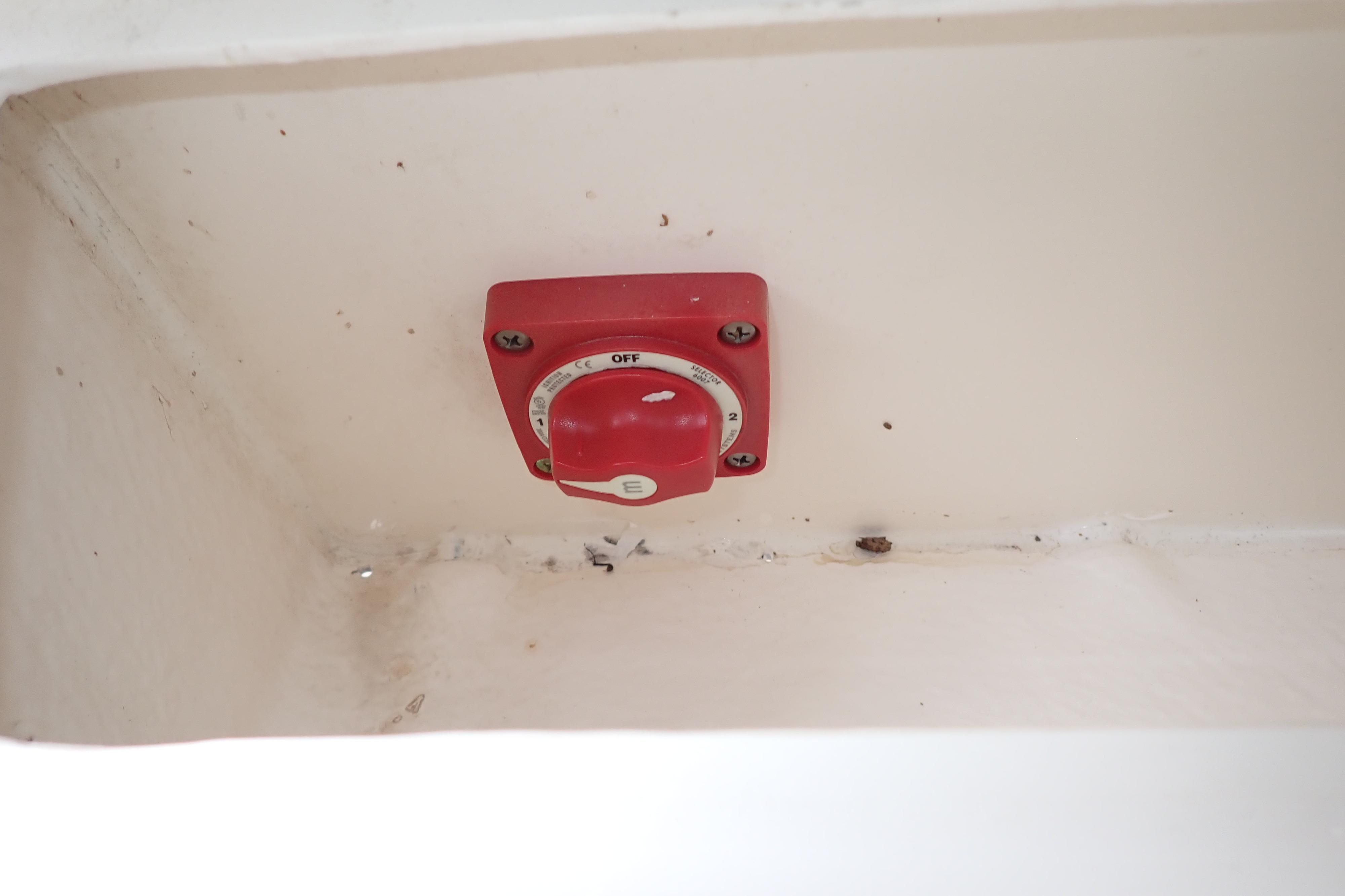 Red battery switch in a 2019 Key West 263 FS boat compartment.