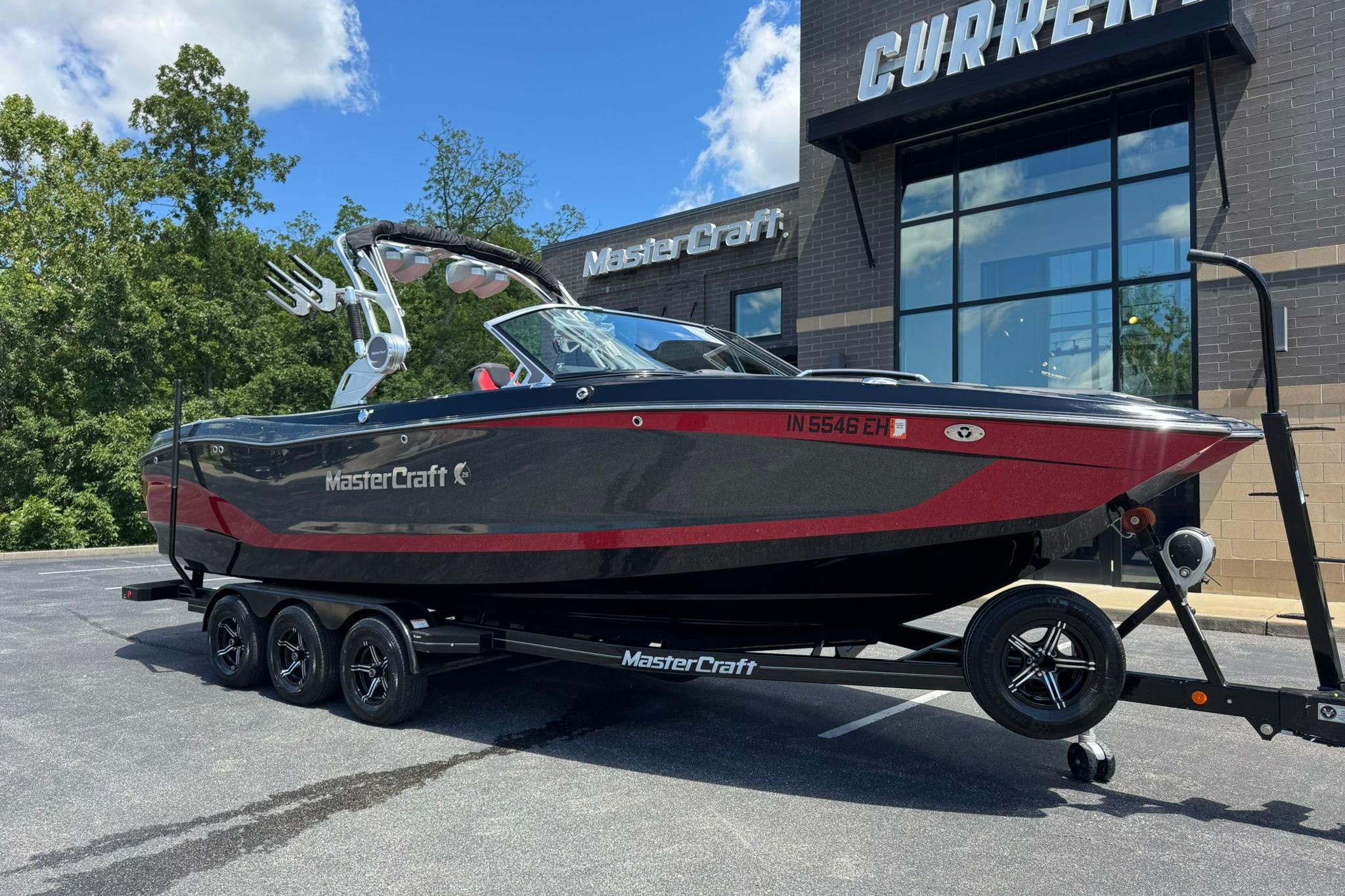 2021 MasterCraft X26 boat on trailer outside dealership, sunny day.