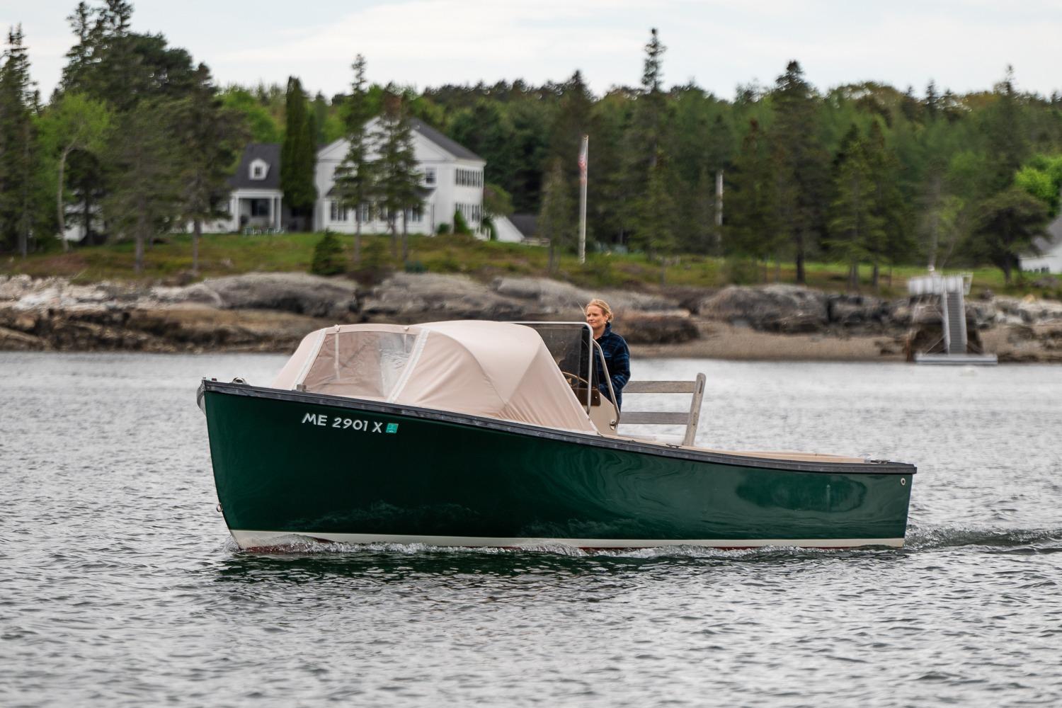 1989 Ellis 24 Open boat cruising on a scenic lake with a forested shoreline.