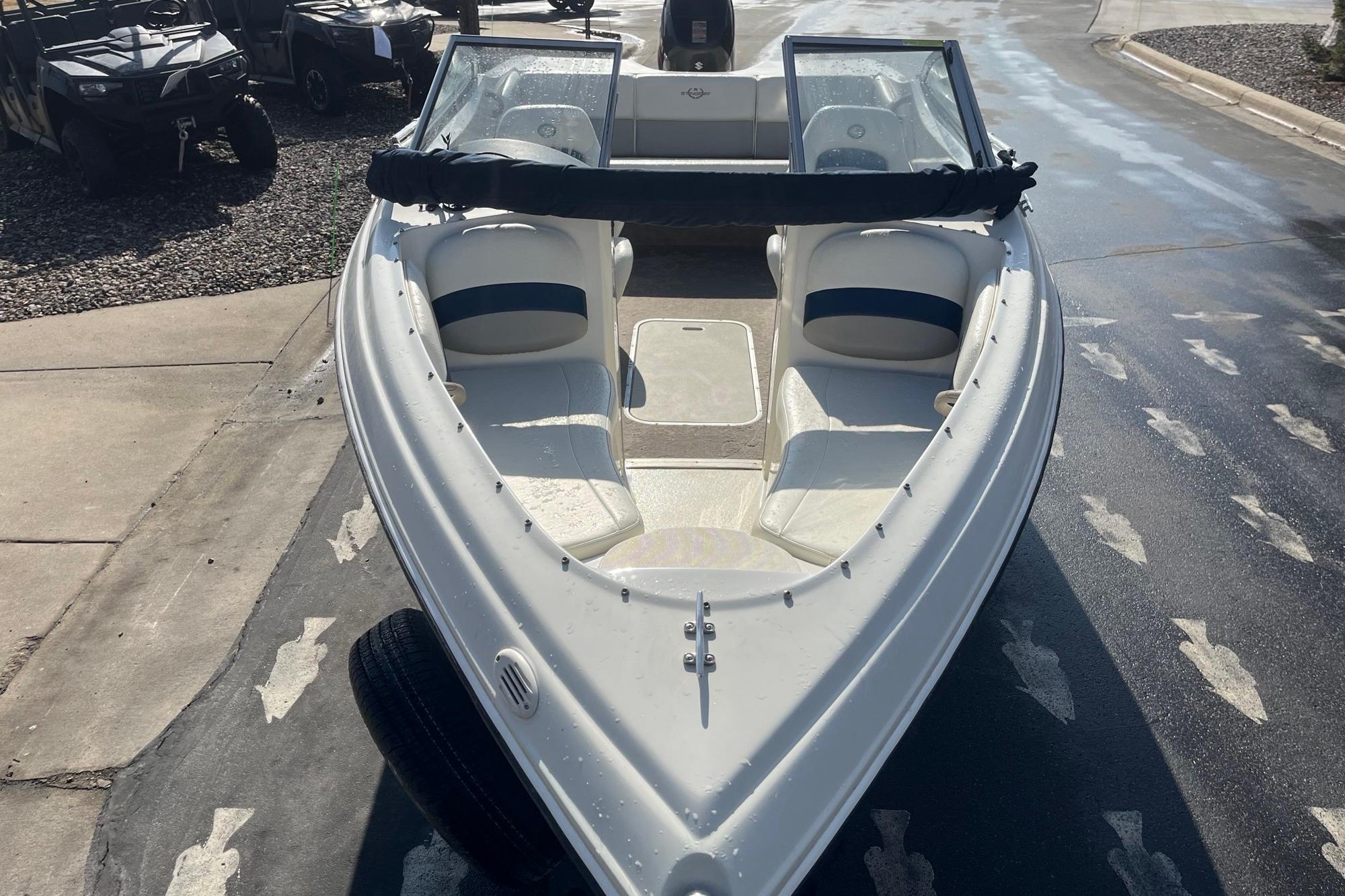 2013 Stingray 191 RX boat, white interior, parked on wet pavement.