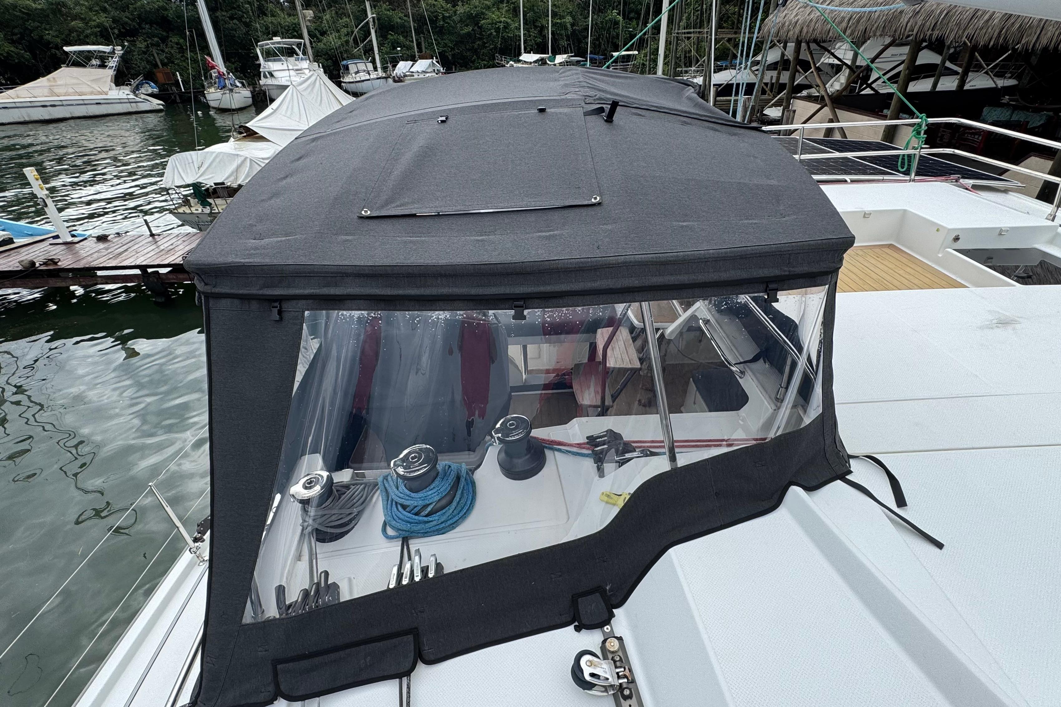 2020 Fountaine Pajot Saona 47 catamaran with covered cockpit, docked in a marina.