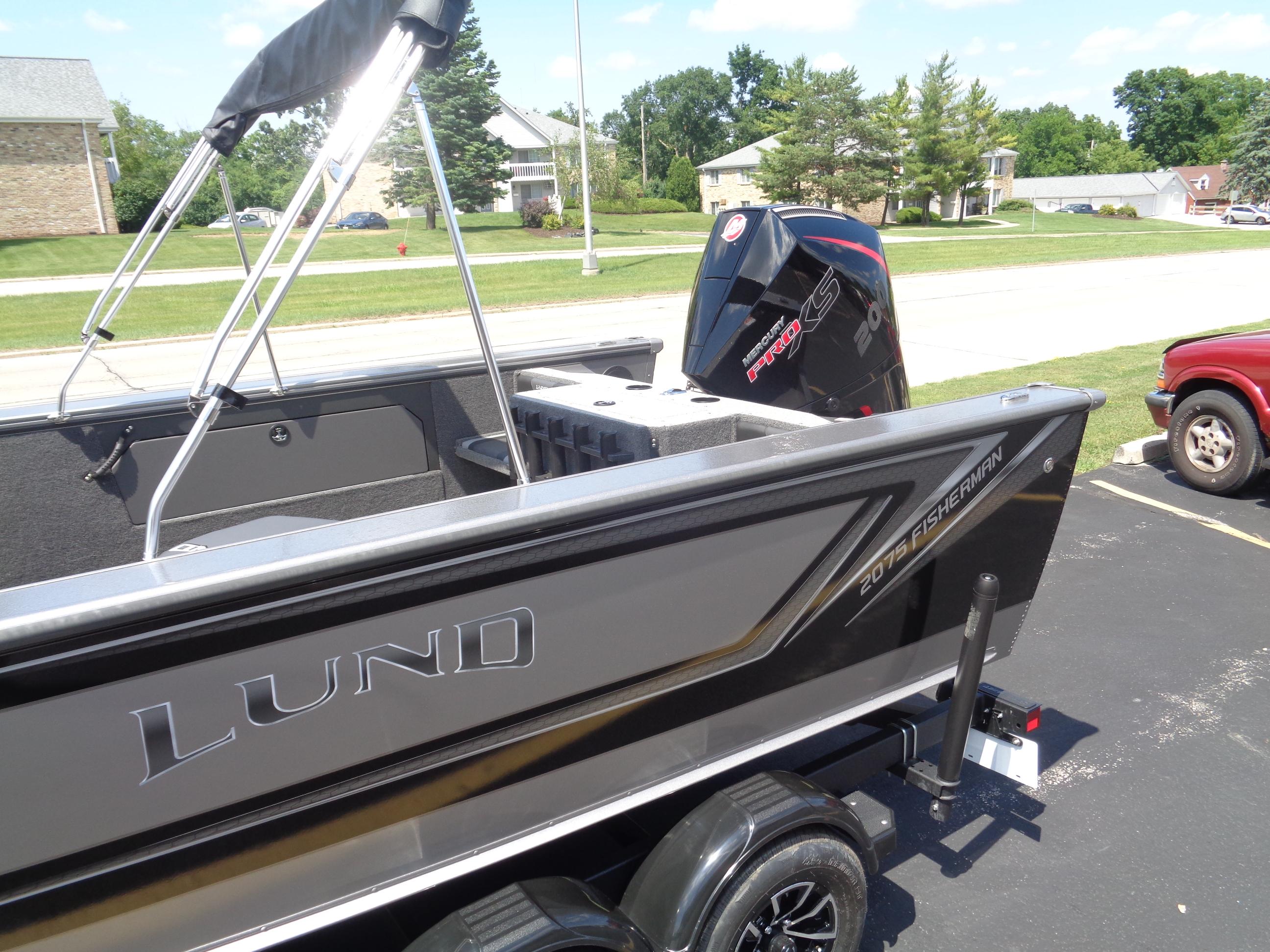 2025 Lund 2075 Fisherman boat with Mercury Pro XS engine, parked outdoors.