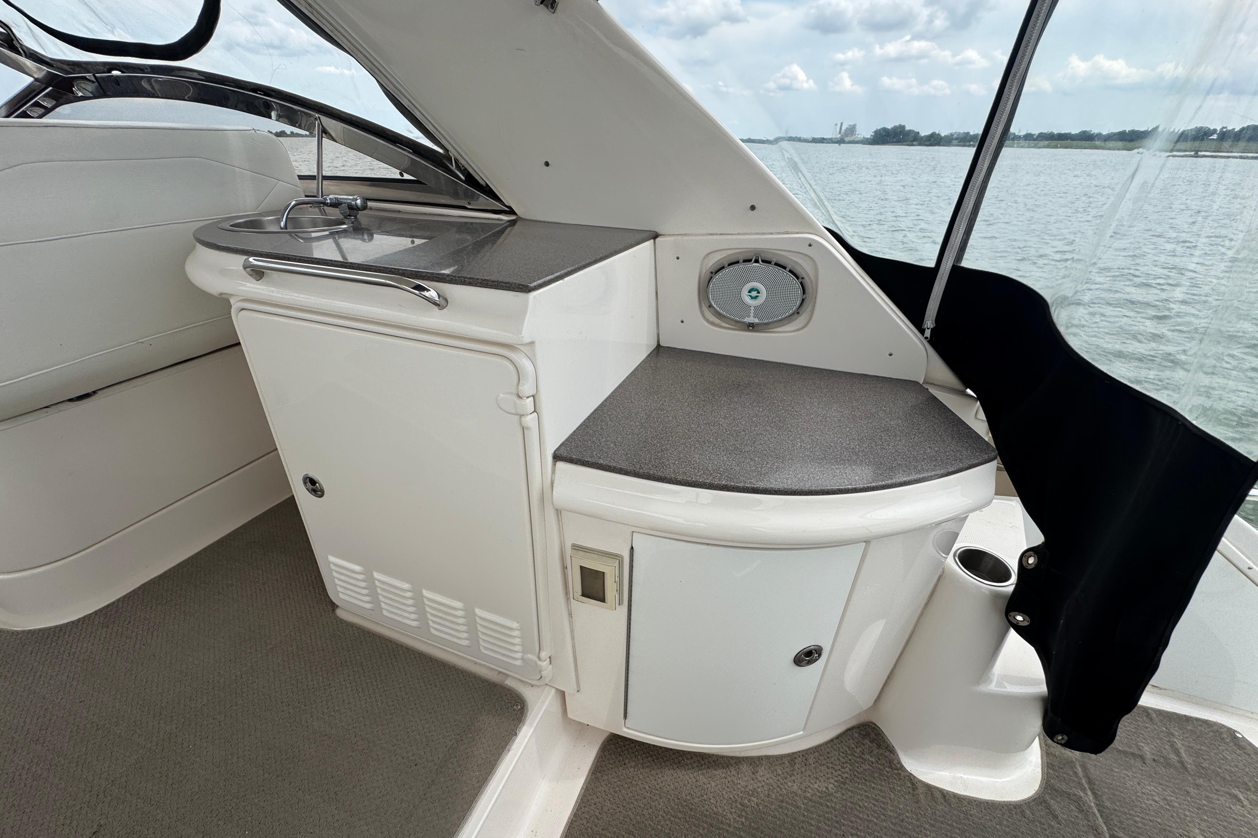 2005 Regal Commodore 4260 yacht interior with kitchenette and sink, overlooking serene waters.