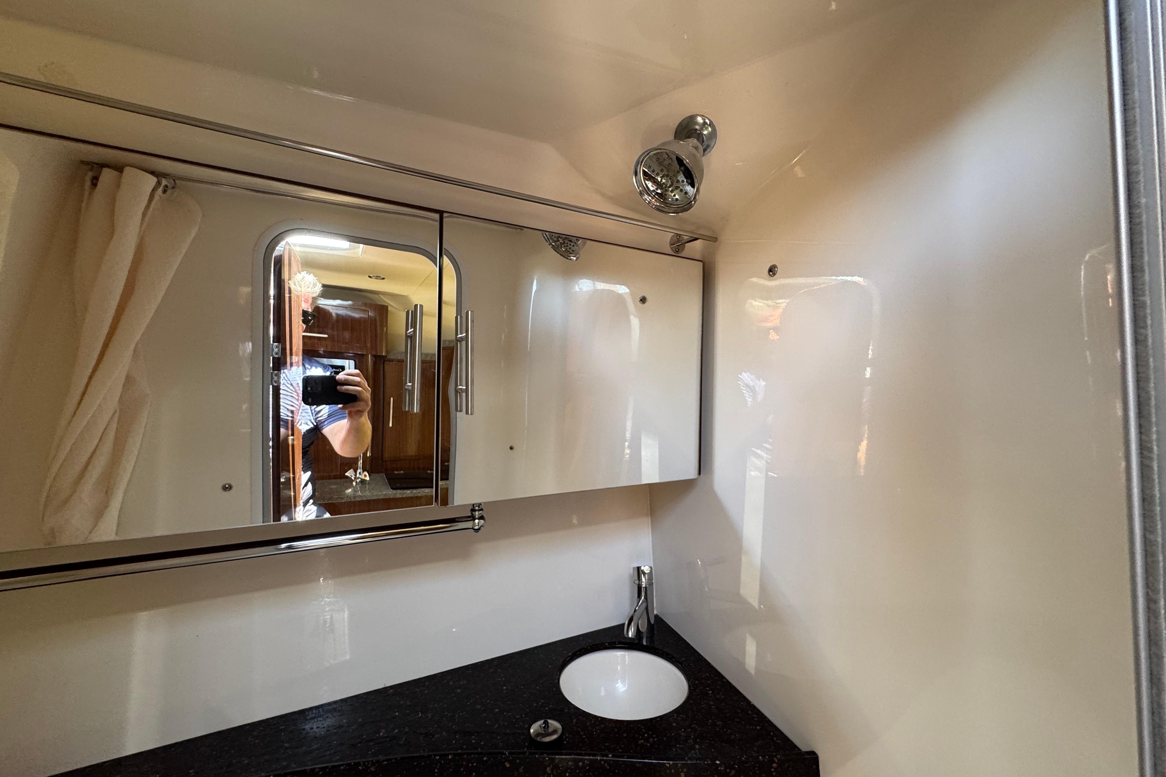 Bathroom interior of 2013 Regal 28 Express boat with mirror and sink.